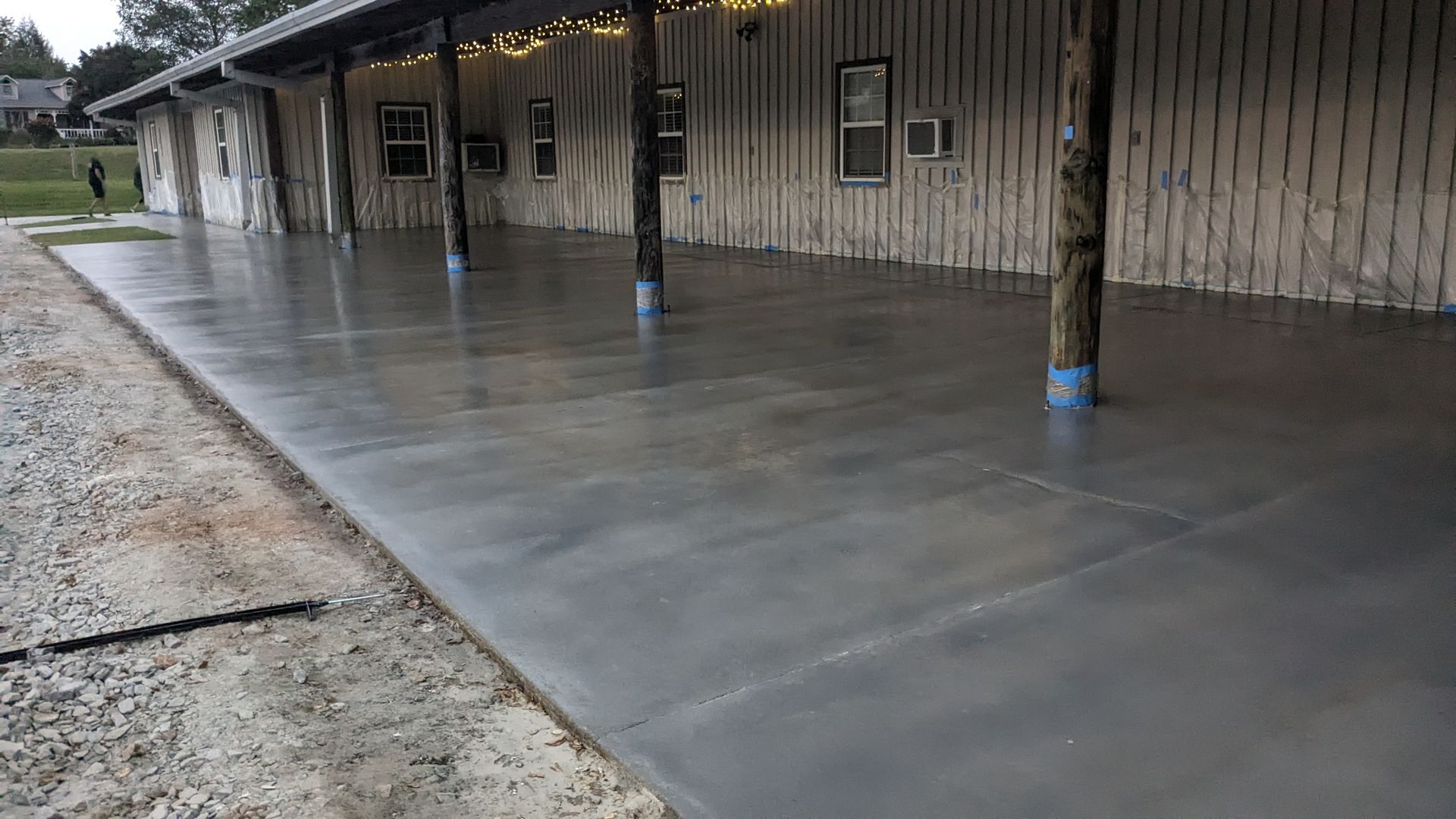 a large concrete patio with a wooden building in the background .