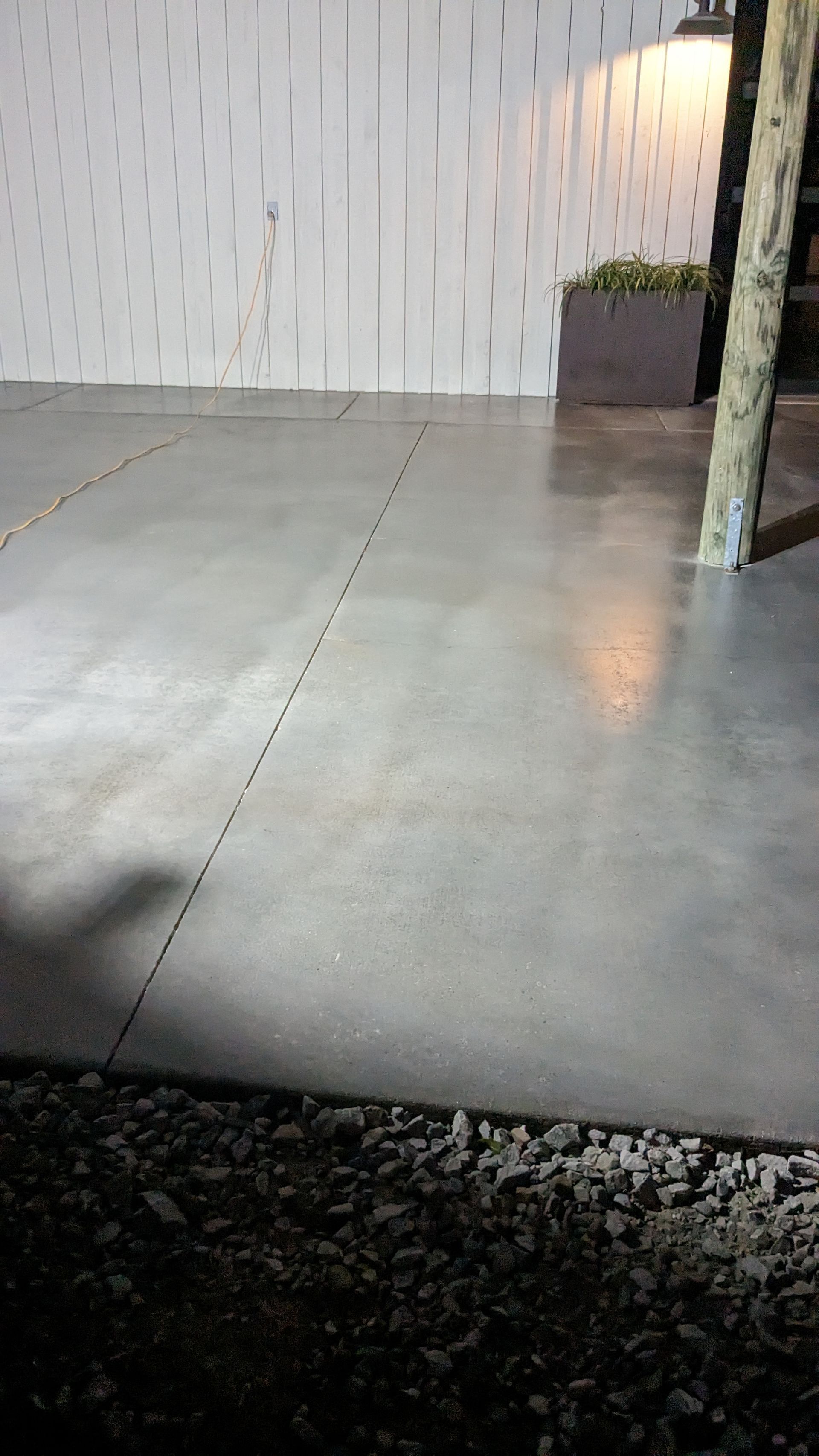 a concrete floor with a tree in the background