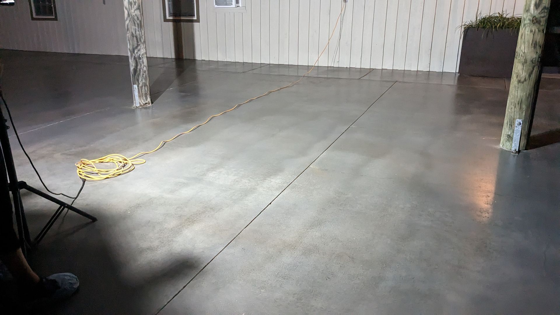 a person is standing in a room with a light on the floor .