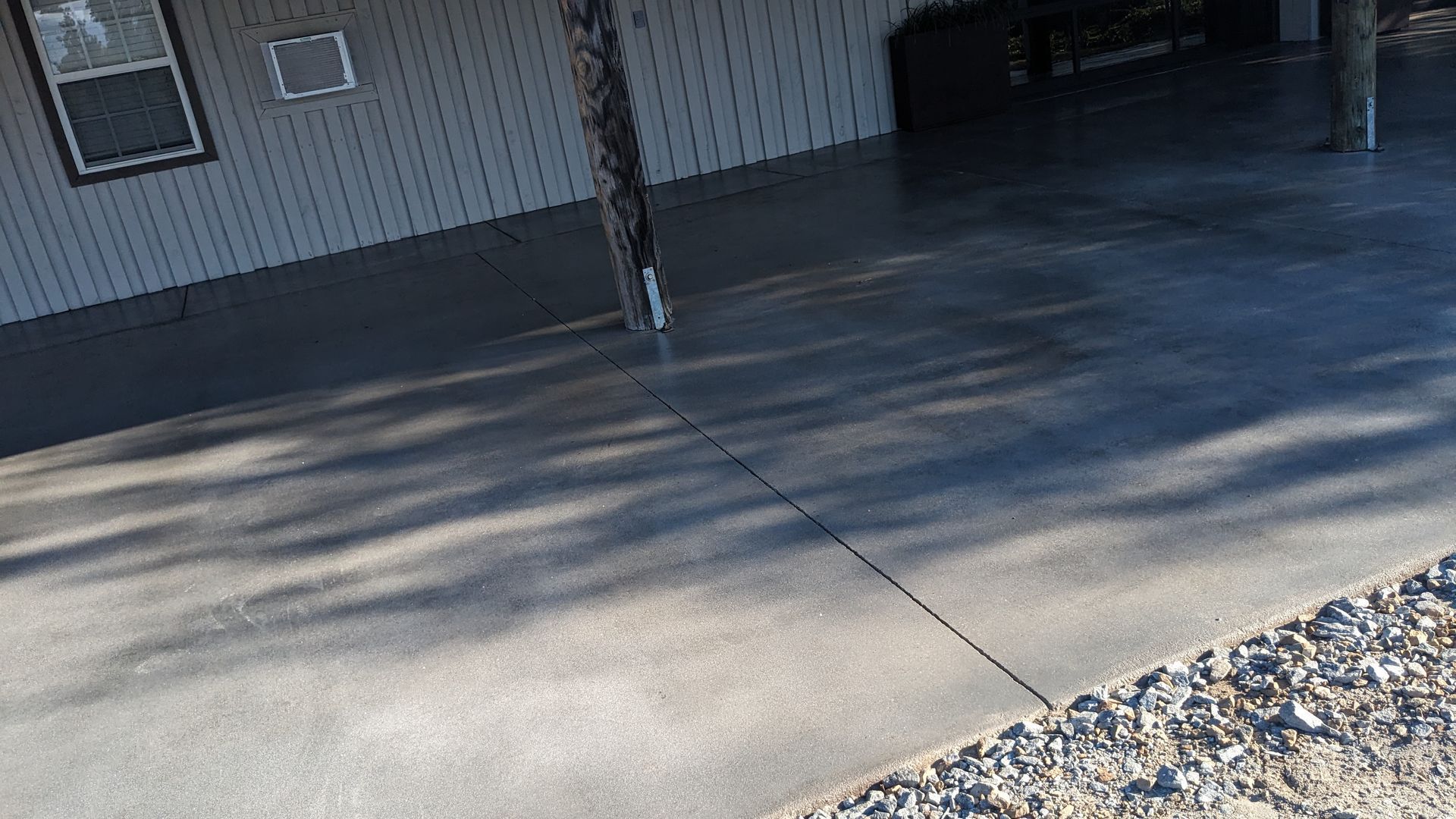 a concrete driveway in front of a house with a covered porch .