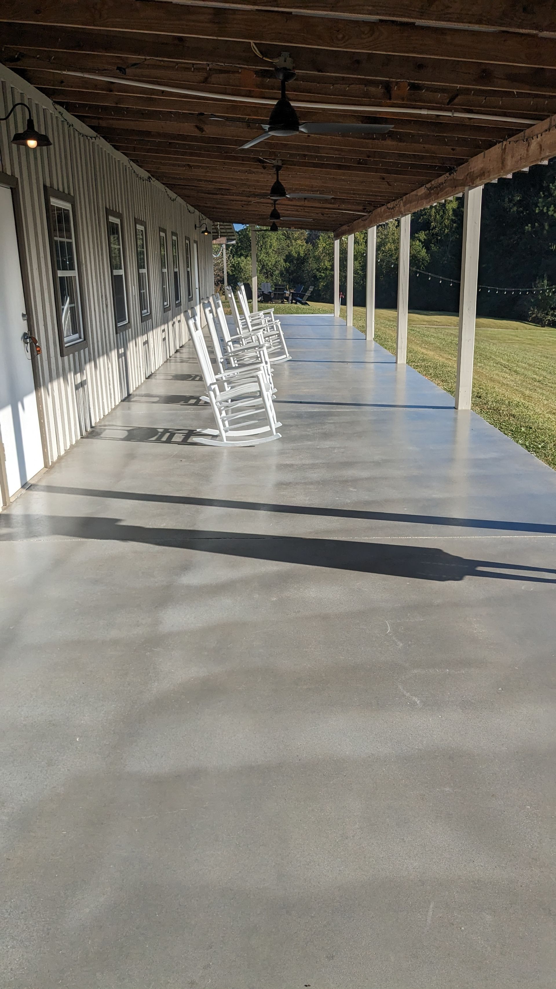 a long covered porch with rocking chairs on it .