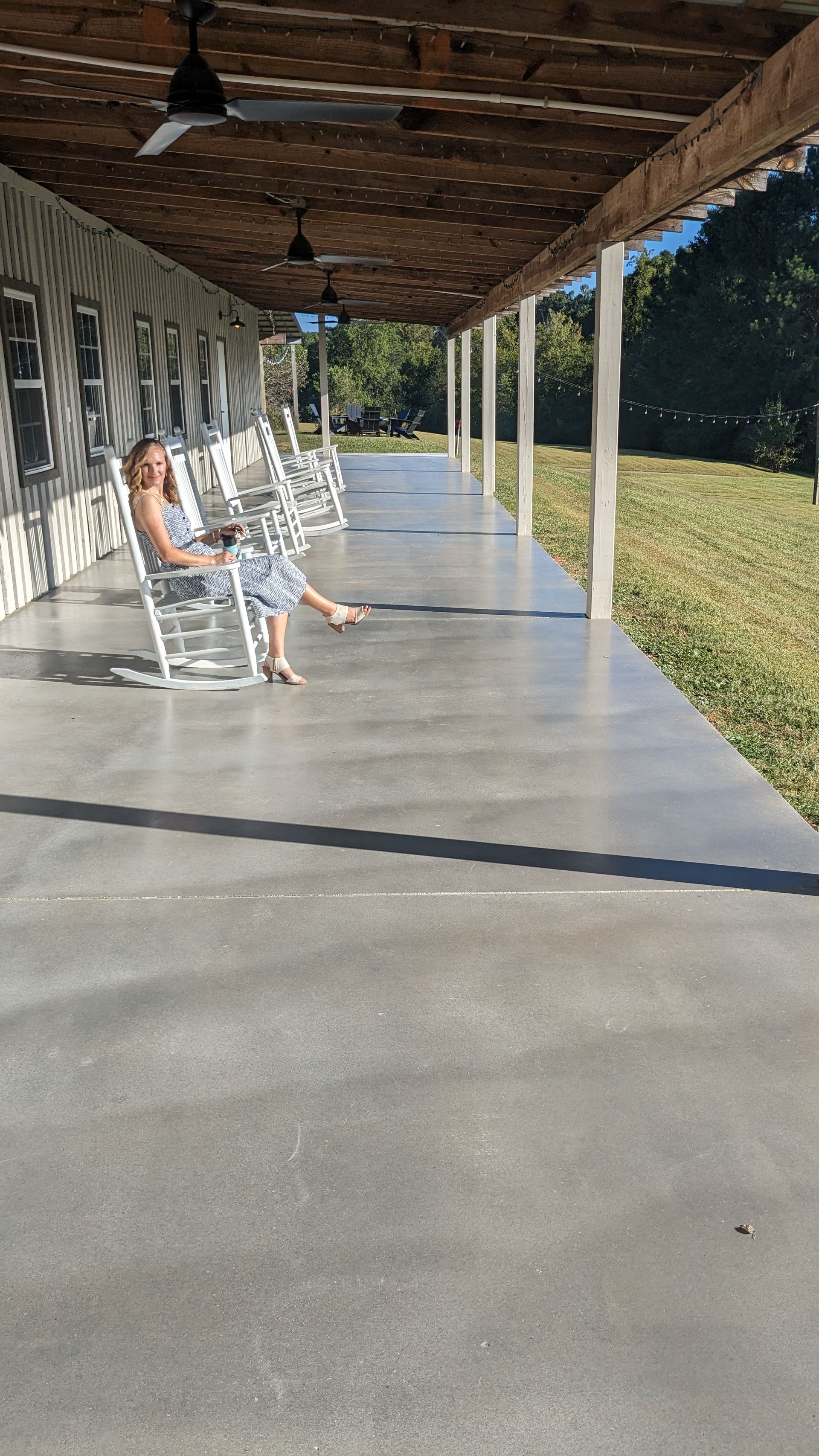 a woman is sitting in a rocking chair on a porch .
