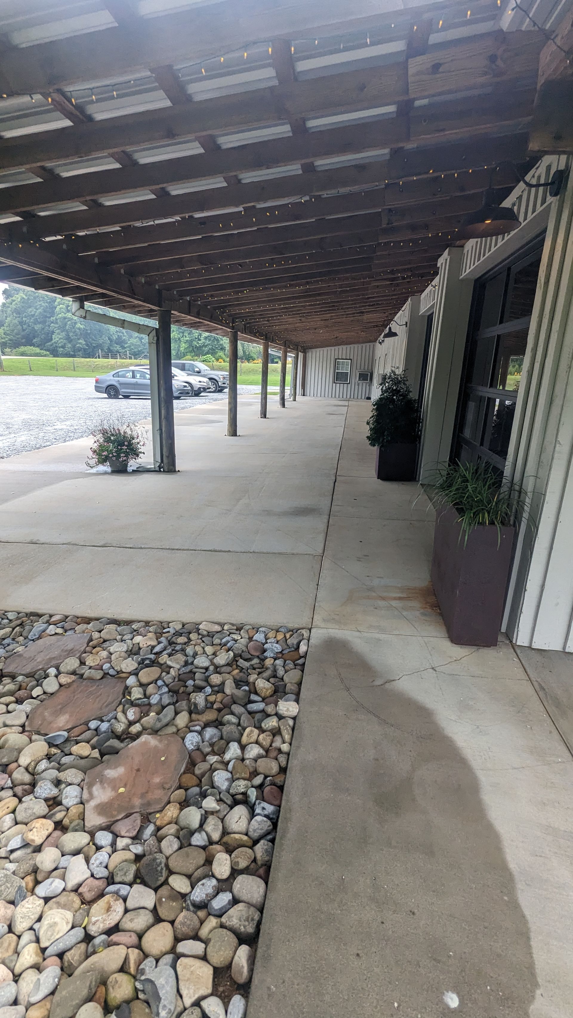 A covered walkway leading to a building with a lot of rocks.