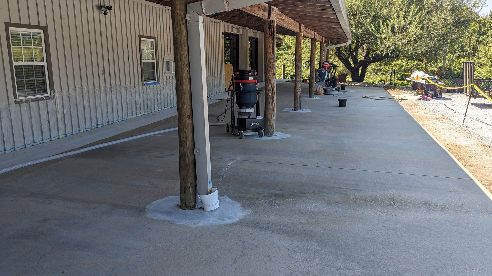 A concrete walkway leading to a house with a covered porch.