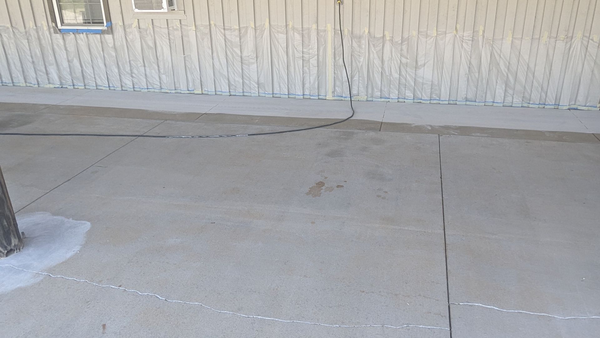 A concrete driveway in front of a building with a tree in the middle of it.