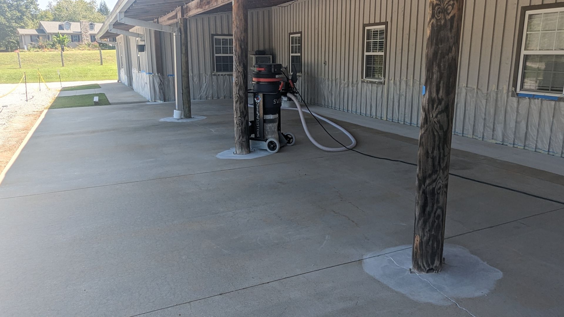 A concrete patio with a vacuum cleaner in front of a building.