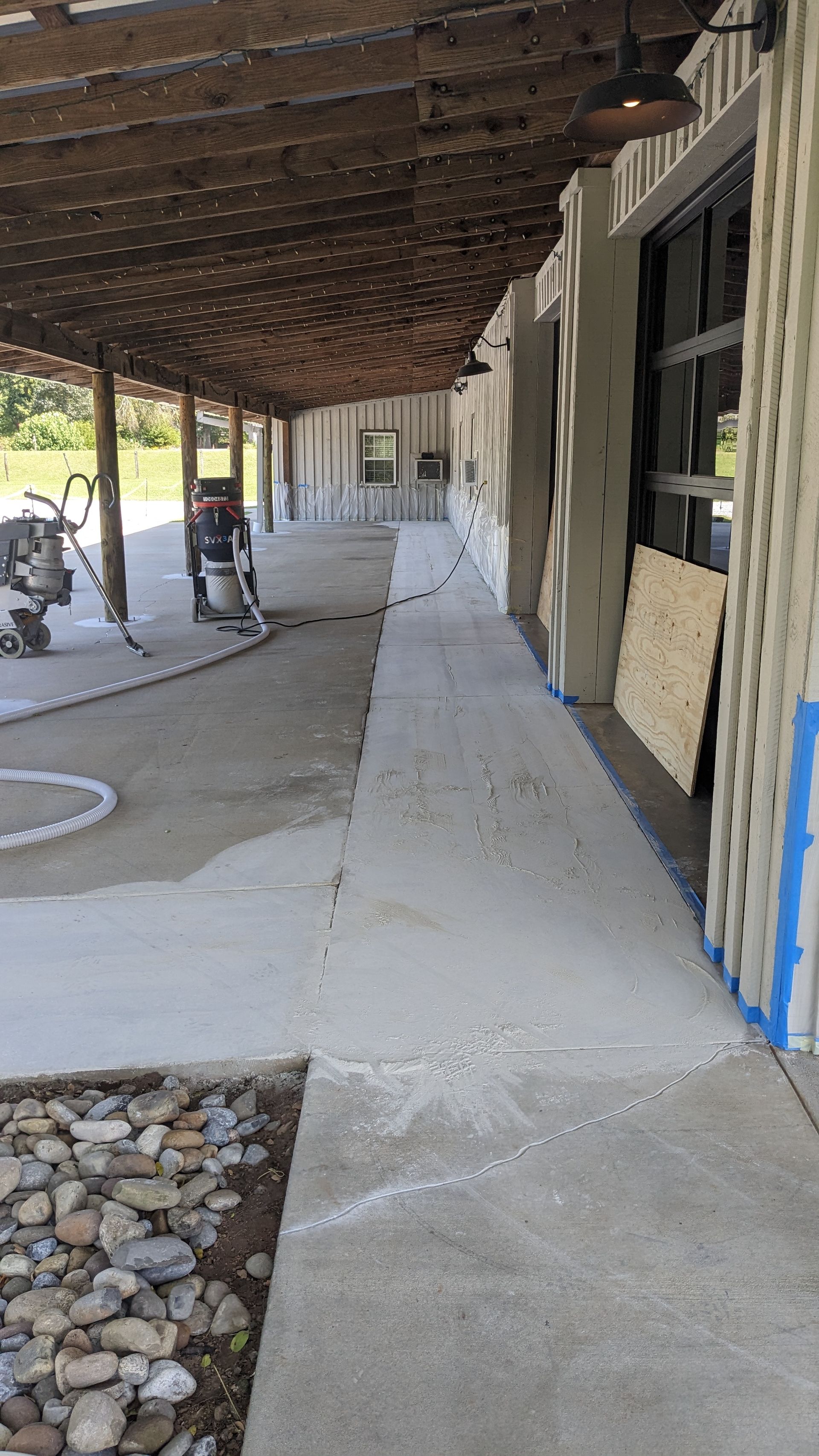 A concrete walkway is being built under a covered porch.