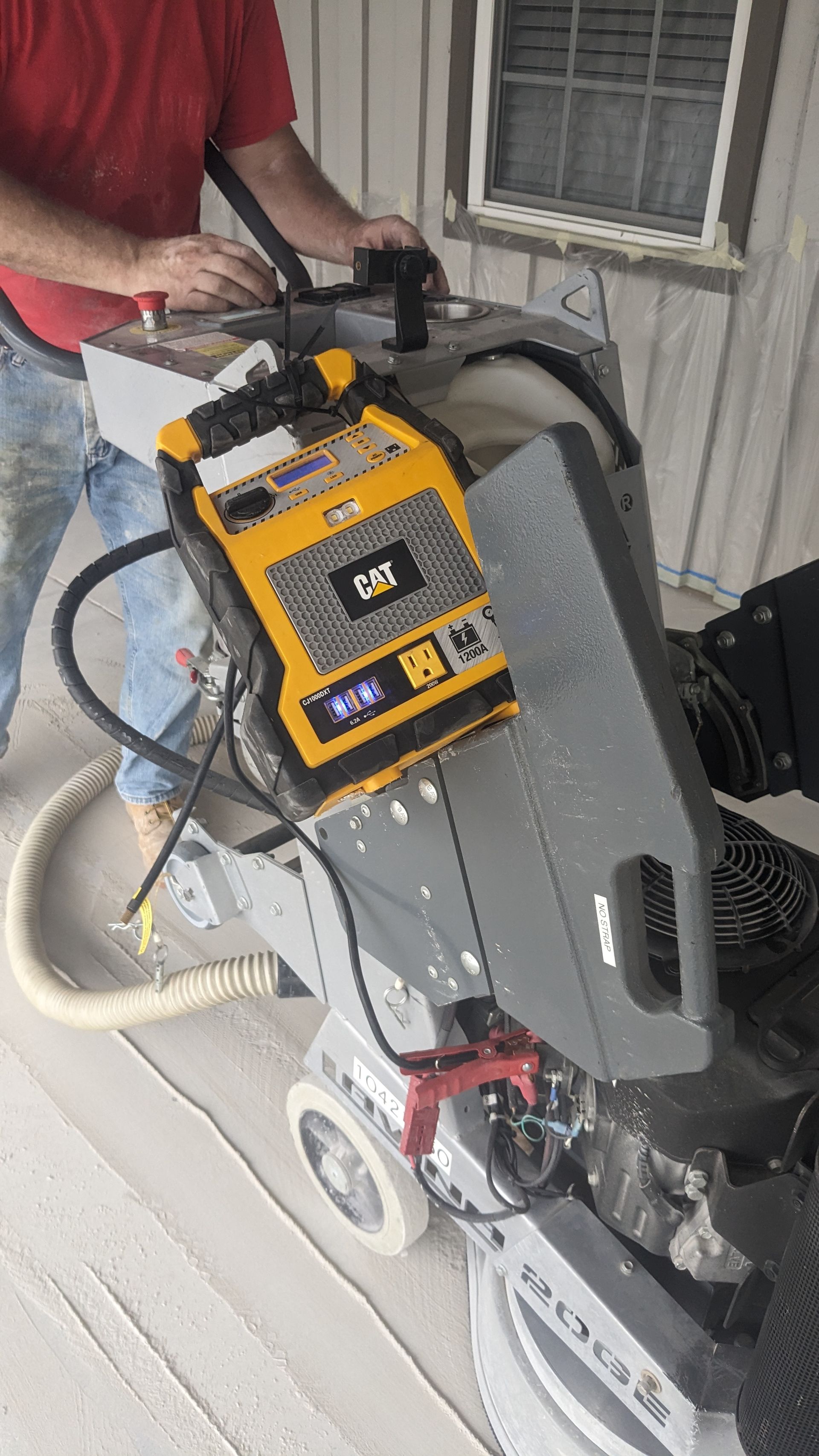A man is using a machine to grind a concrete floor.