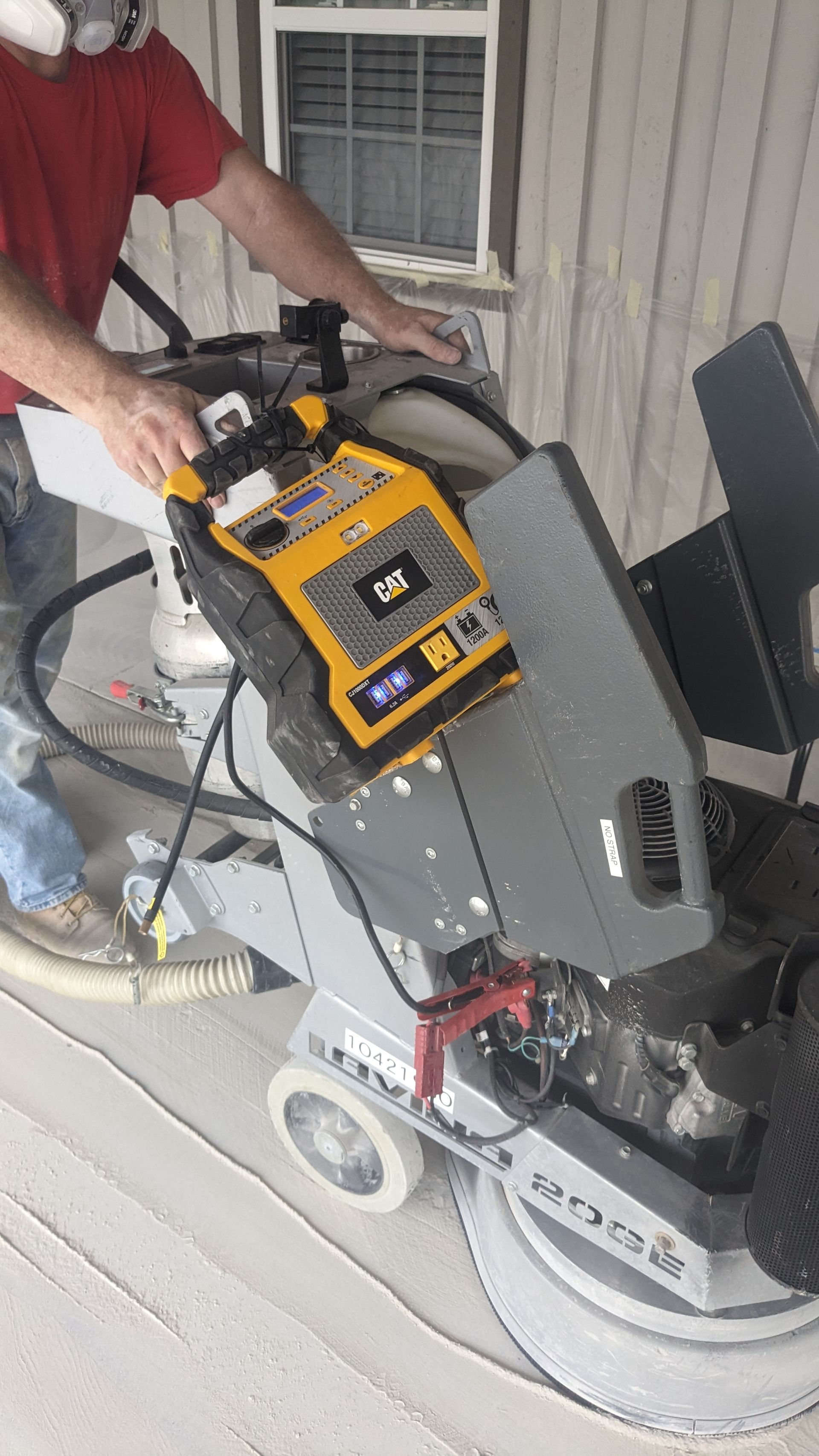 A man is using a machine to polish a concrete floor.