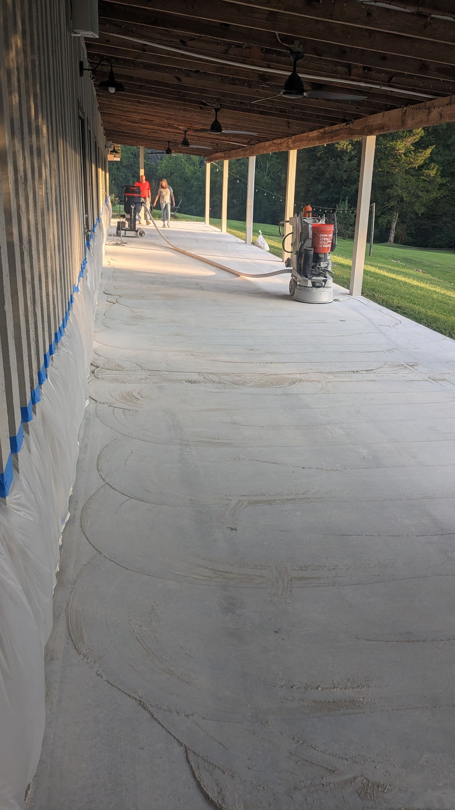 A concrete walkway with a wooden roof is being painted.