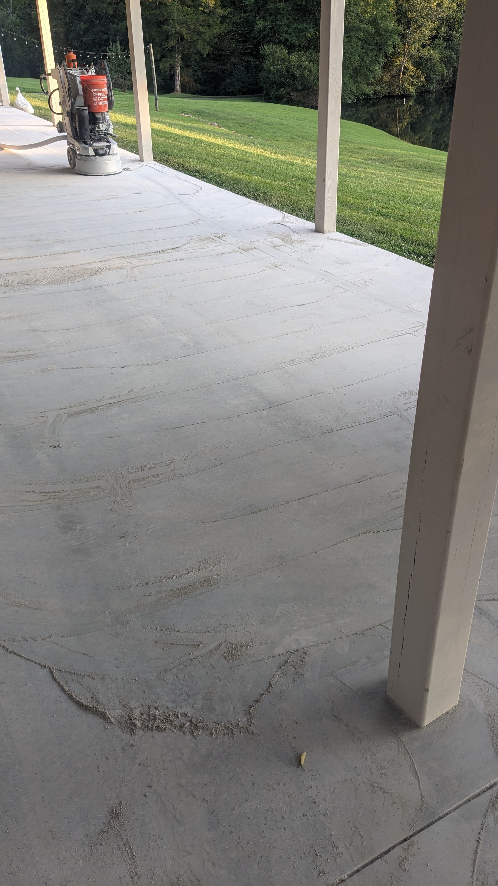A person is using a grinder on a concrete patio.