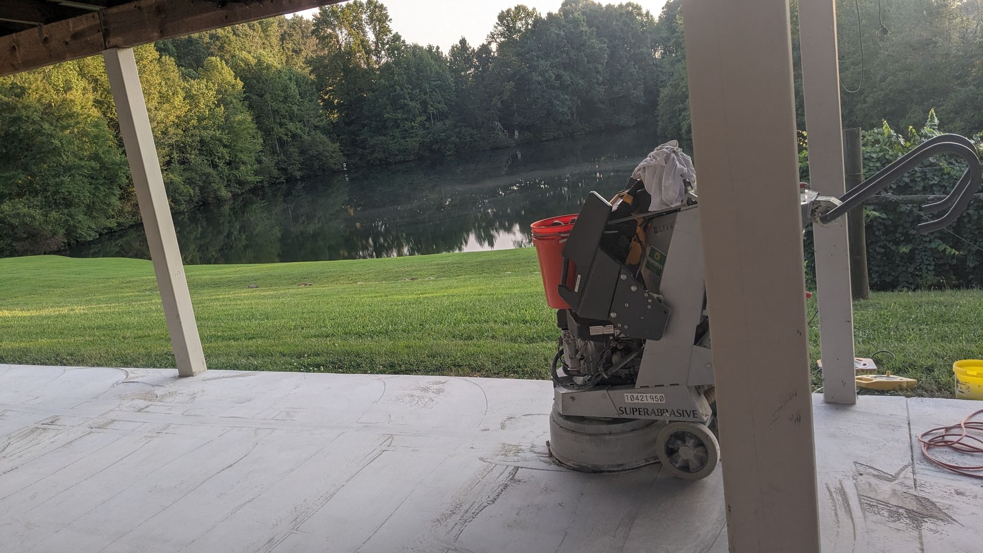 A machine is sitting on a patio next to a lake.