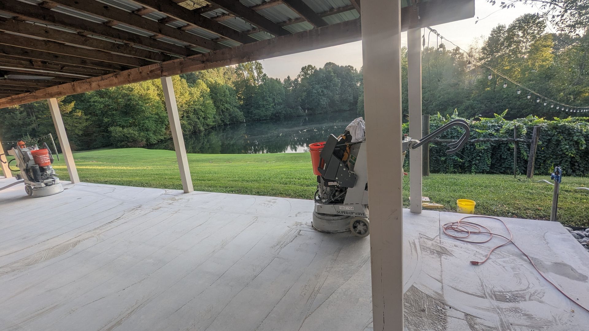 A patio with a grinder on it and a view of a lake.