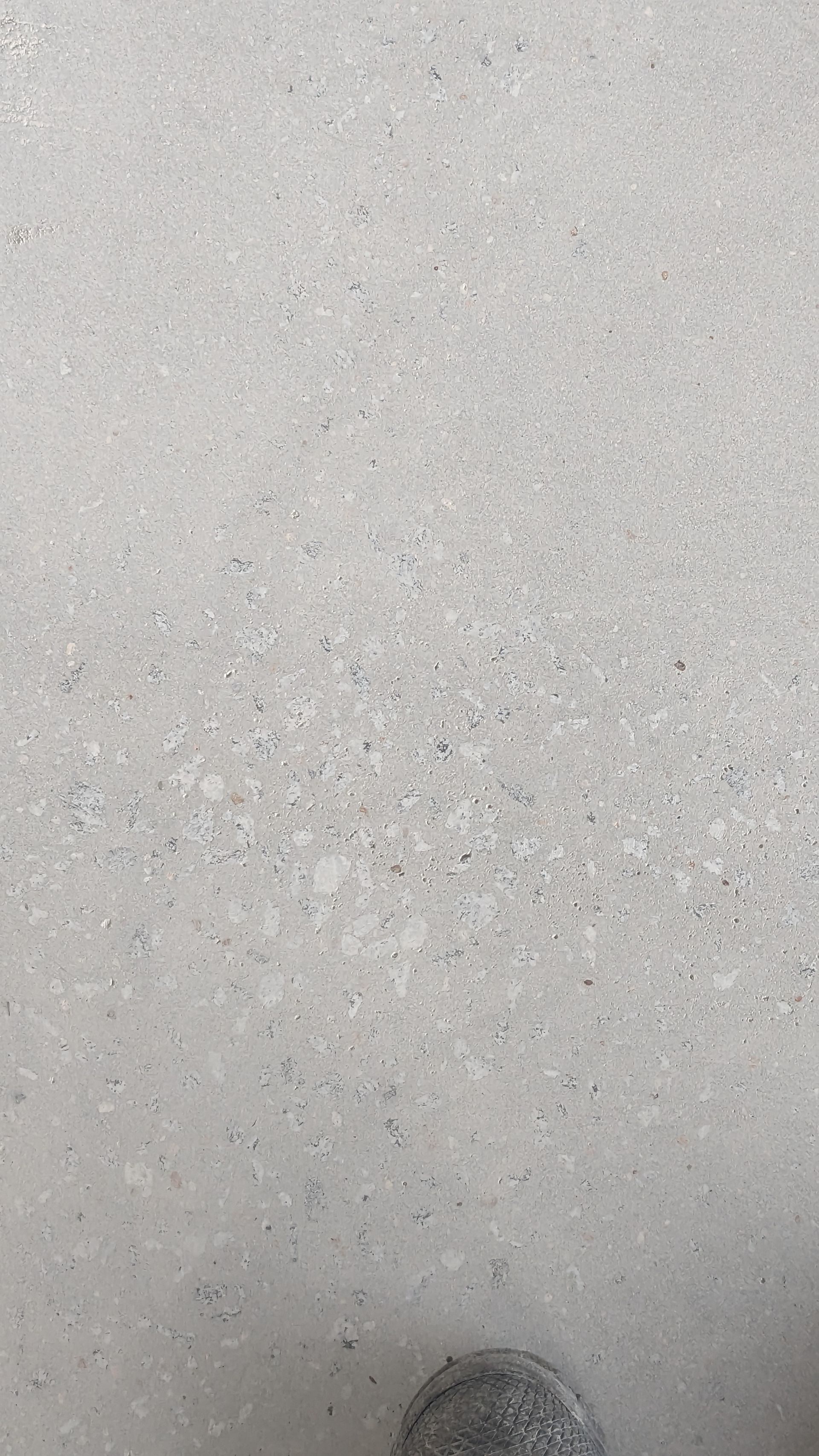 A close up of a white surface with a coin in it.