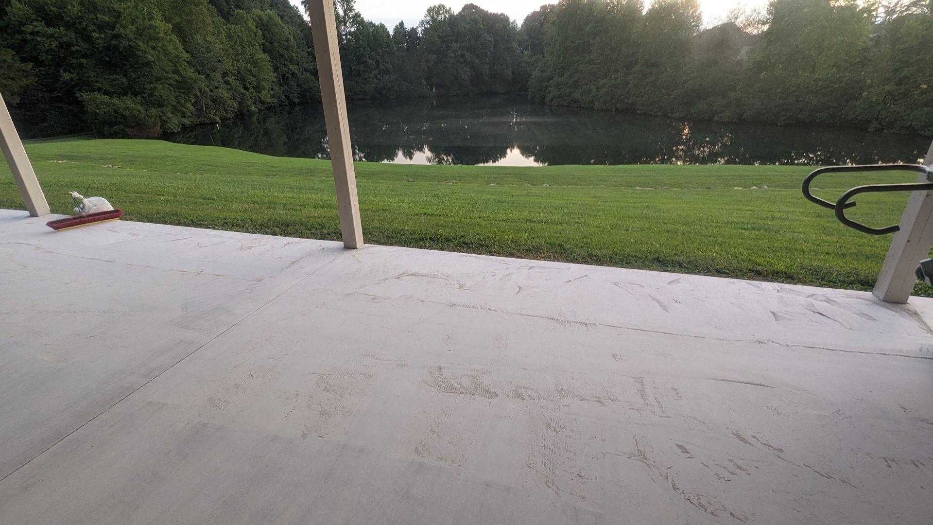 A patio with a view of a lake and trees.