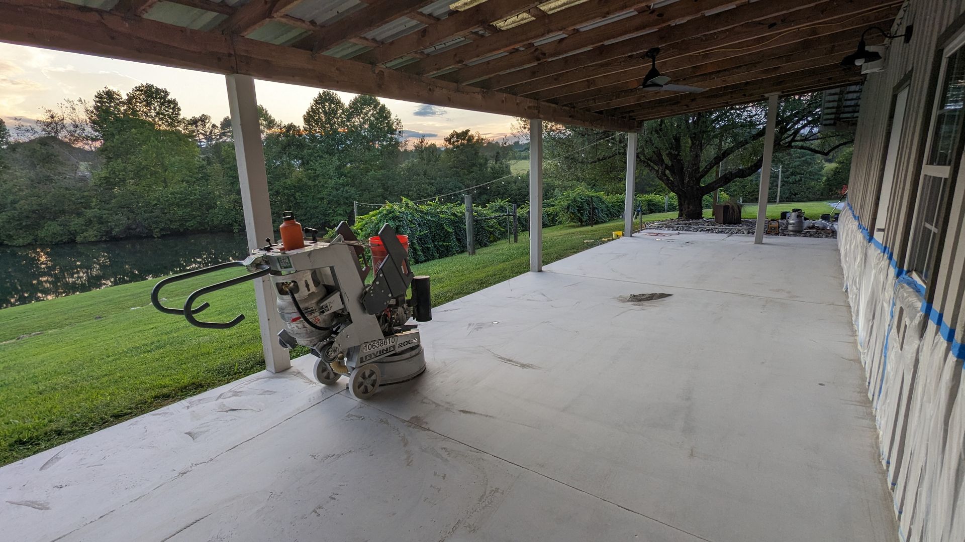 A machine is grinding a concrete floor on a porch.