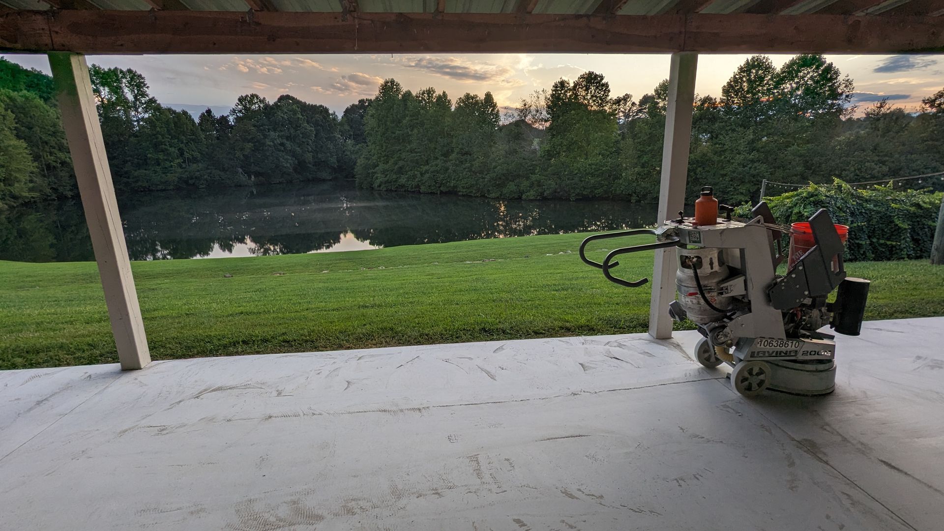A machine is sitting on a patio next to a lake.