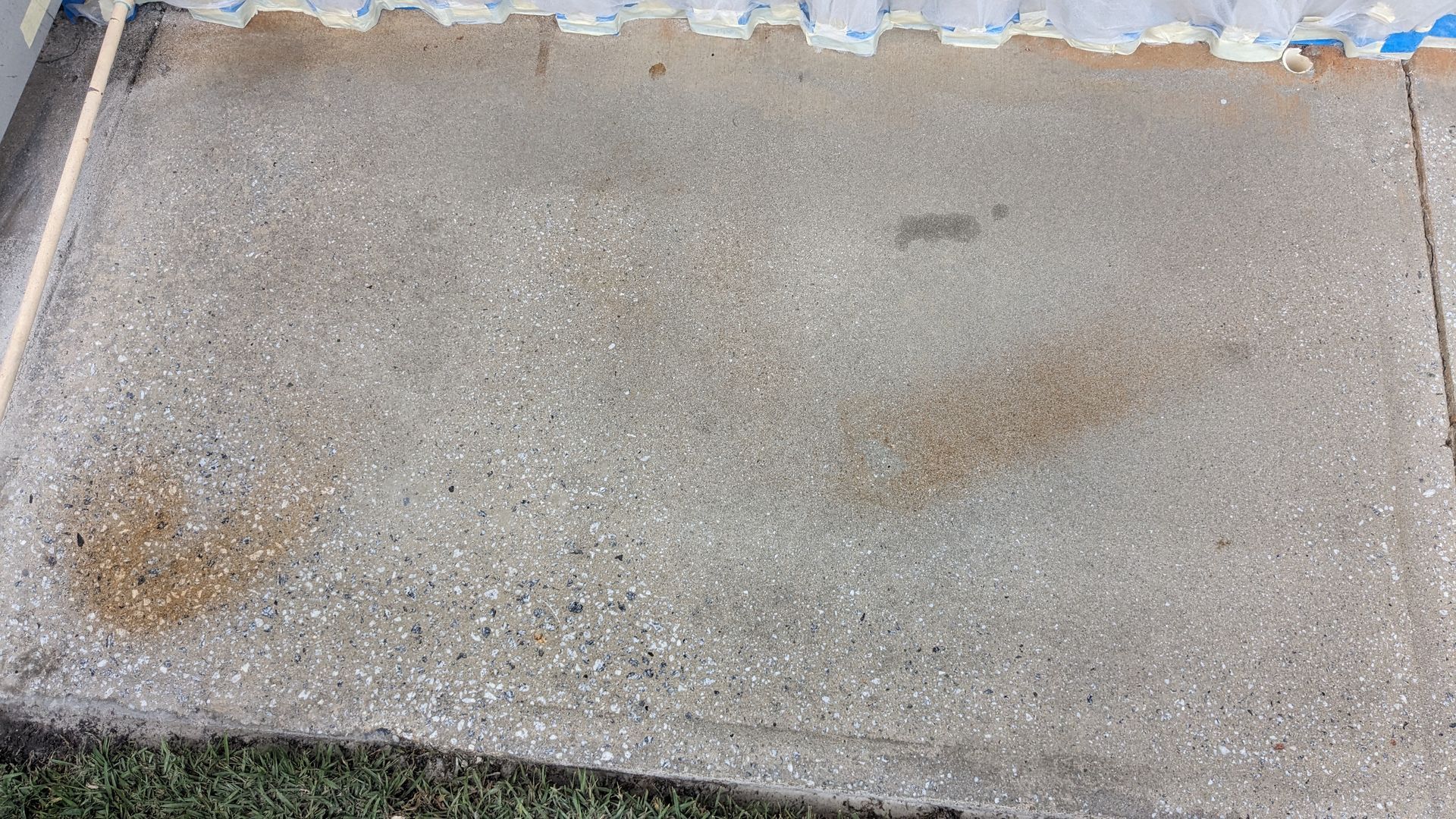 A concrete floor with a few spots of brown on it.
