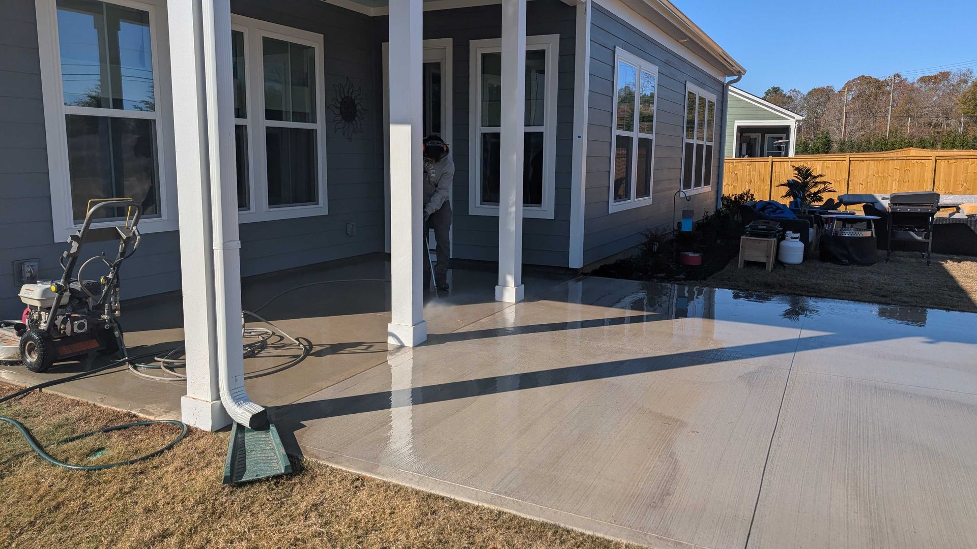 A house with a porch and a patio in front of it.