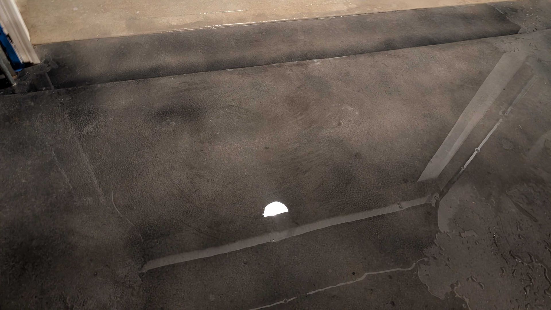 A close up of a concrete floor with a hole in it.