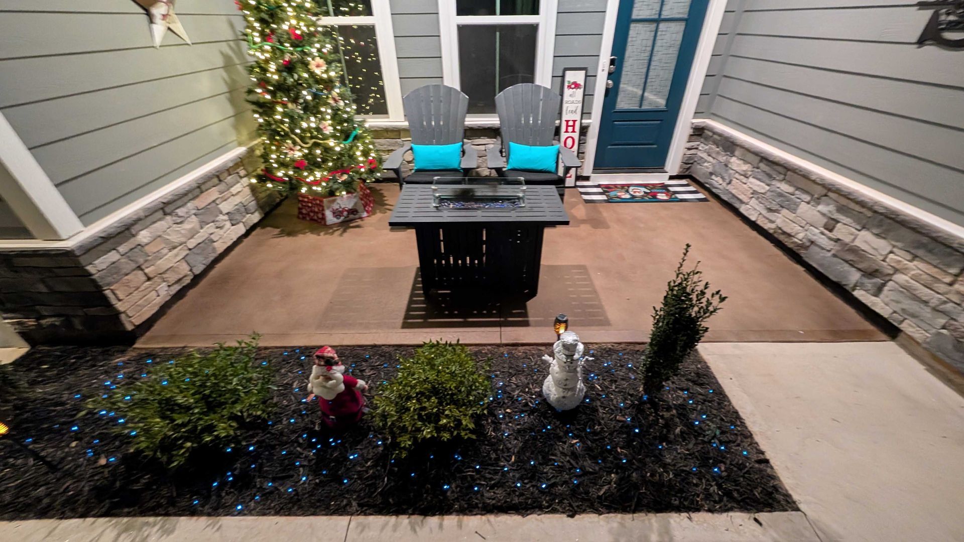 A patio with a table and chairs and a christmas tree in the background.