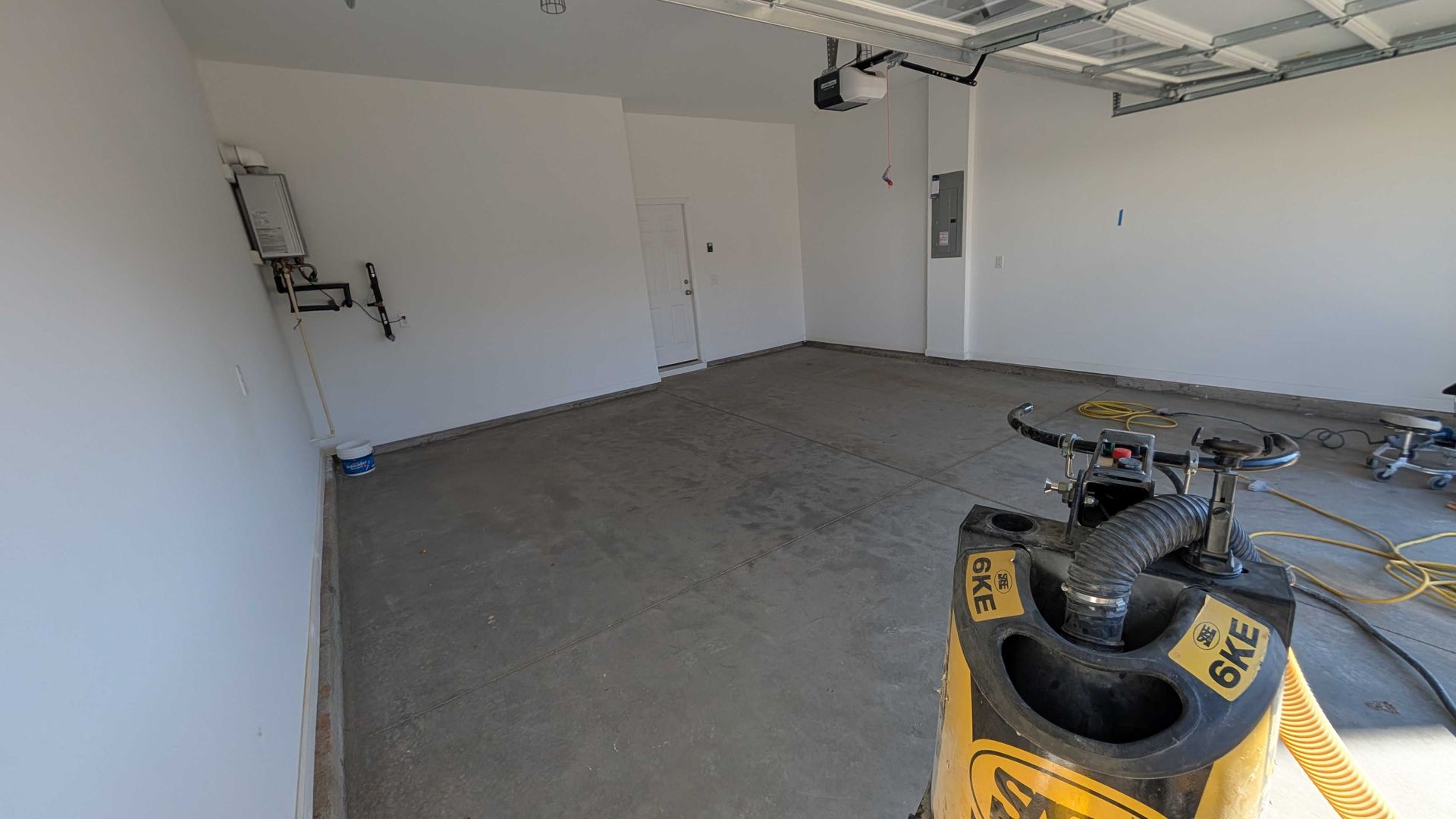 An empty garage with a bag of concrete in the middle of it.