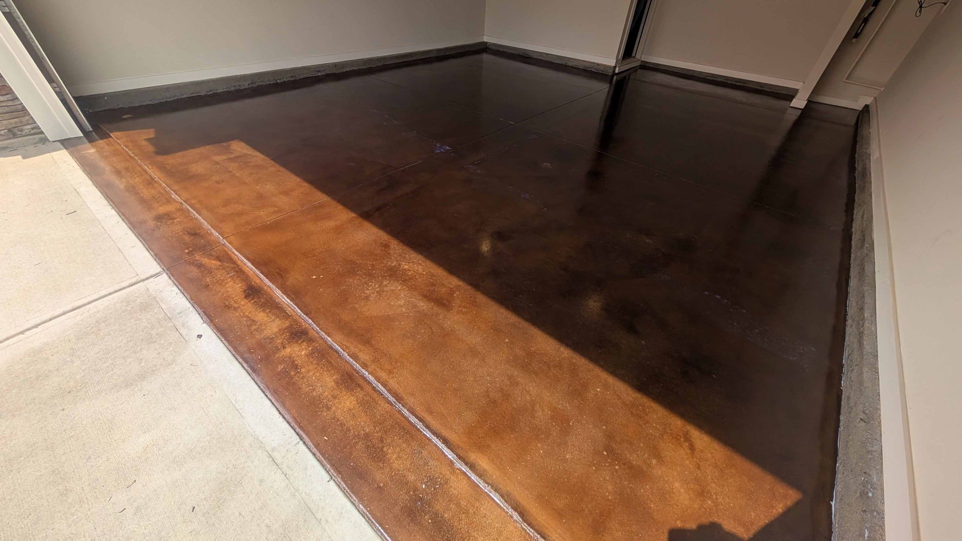 A dark colored concrete floor with a wooden border and steps.