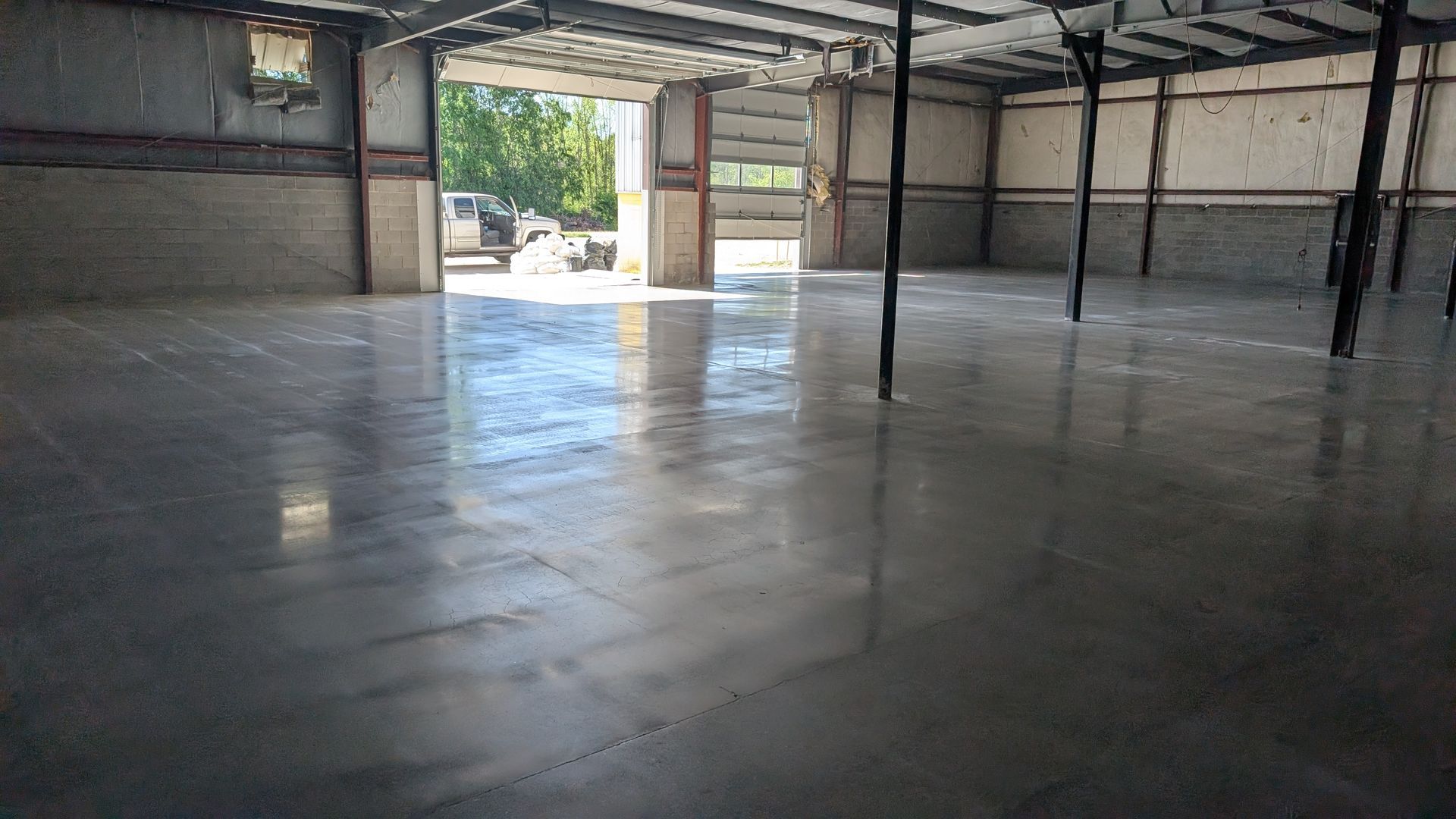 Shiny sealed concrete surface with window reflection installed by Zachary Daniel Concrete in Duncan, SC.