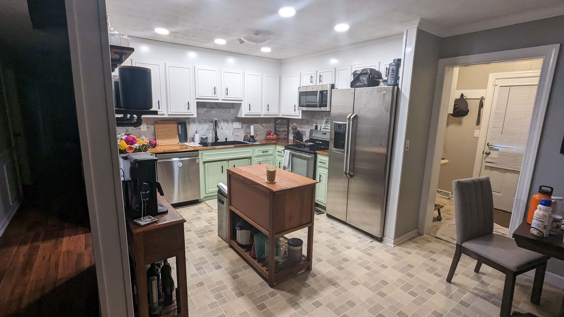 A kitchen with stainless steel appliances and a large island in the middle.