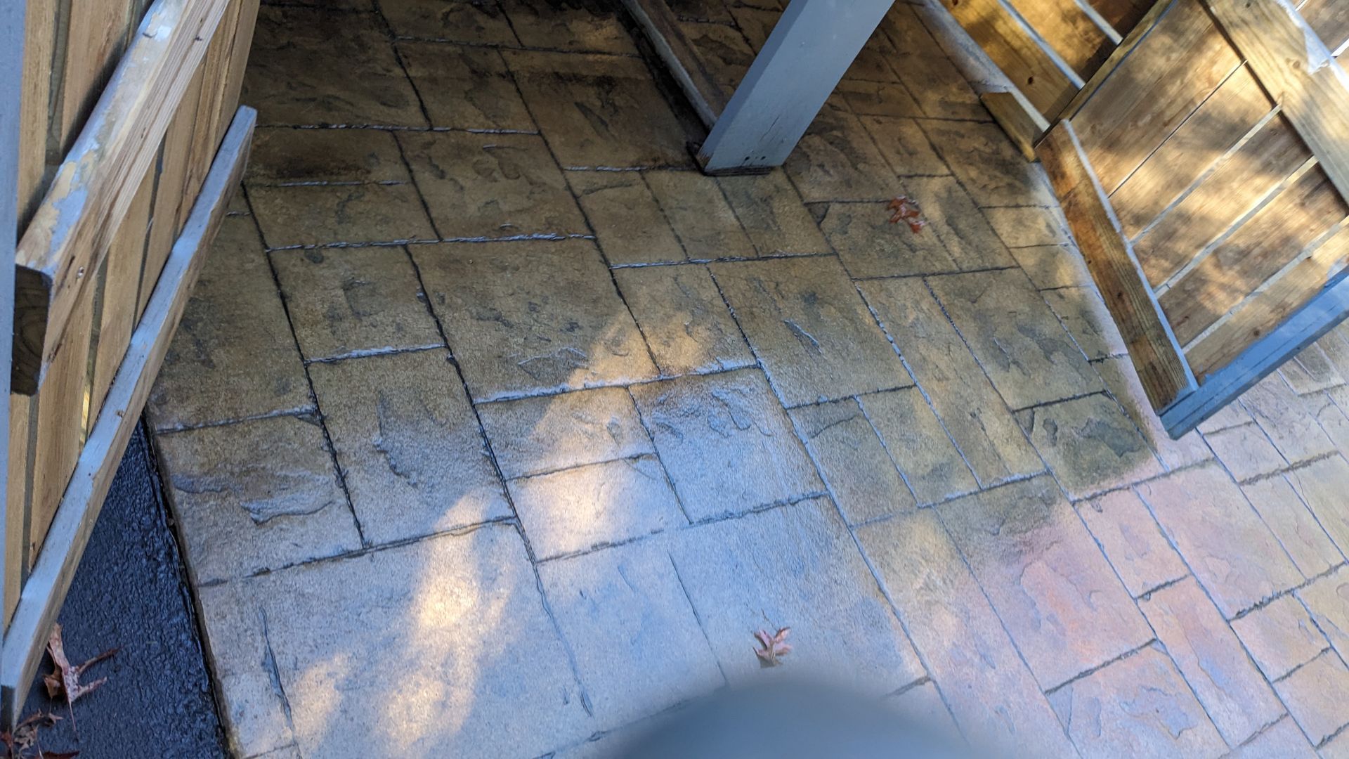 A brick floor with a wooden fence in the background.