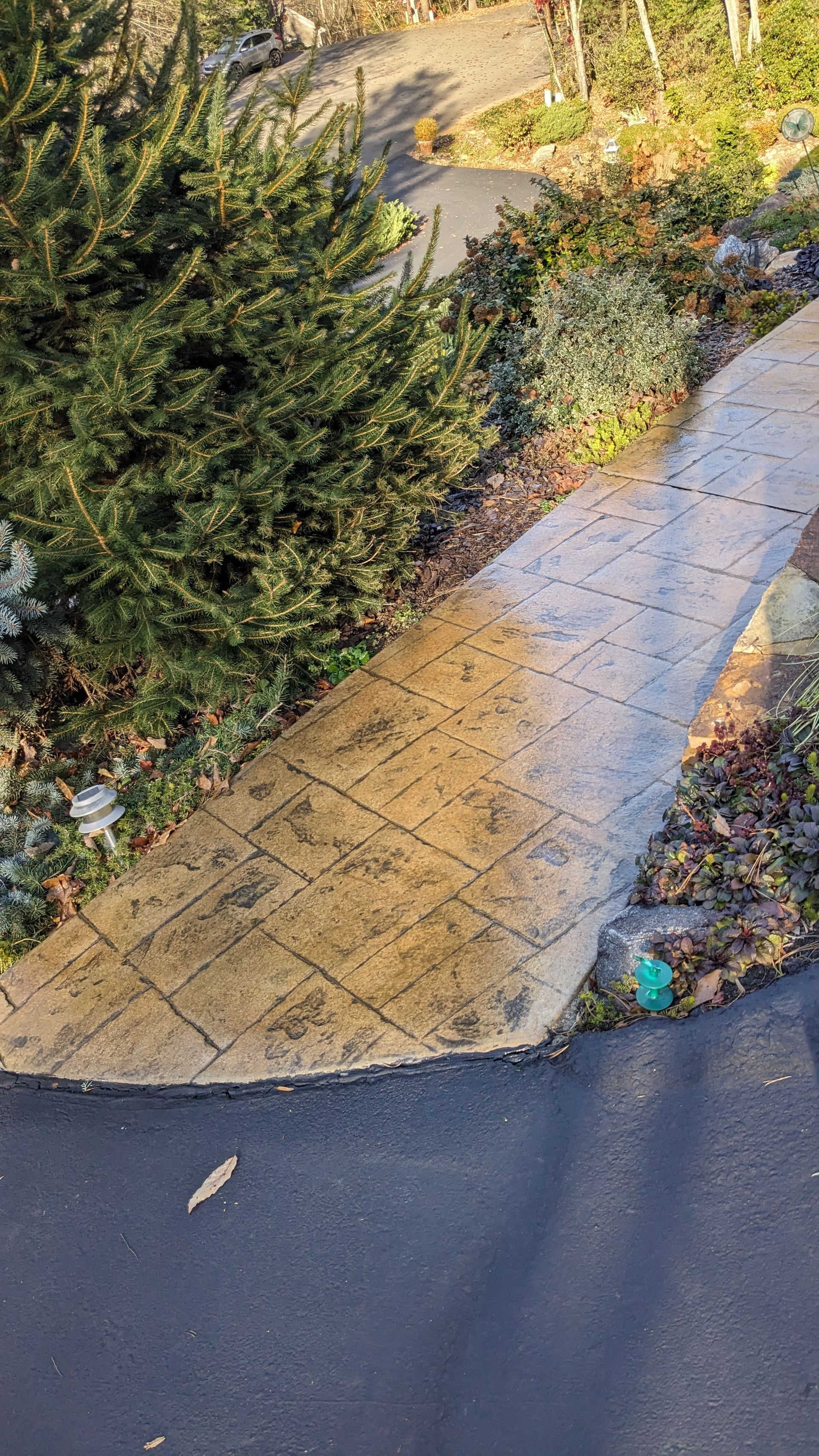 An aerial view of a concrete walkway leading to a house.