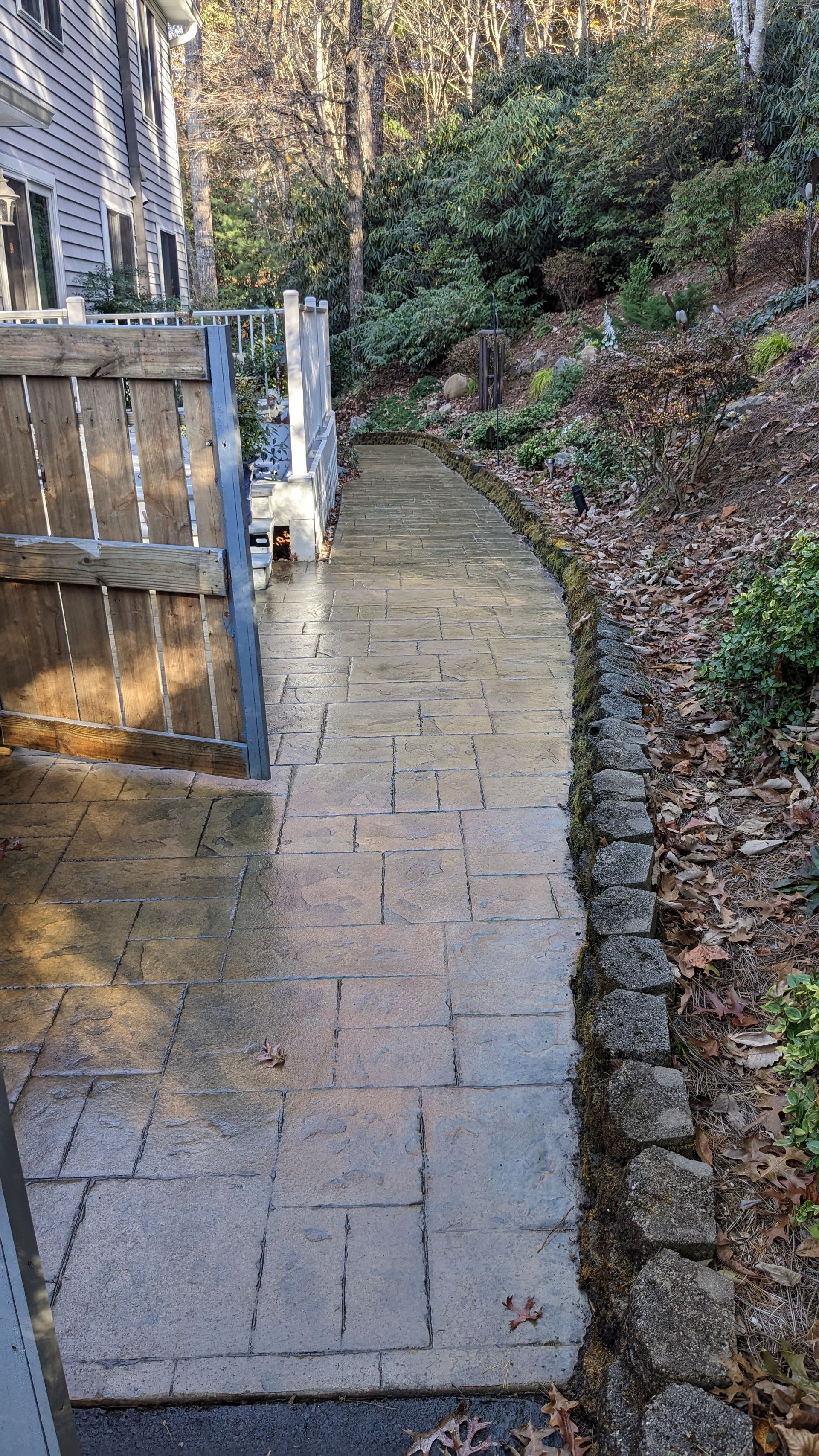 A brick walkway leading to a house in the woods.