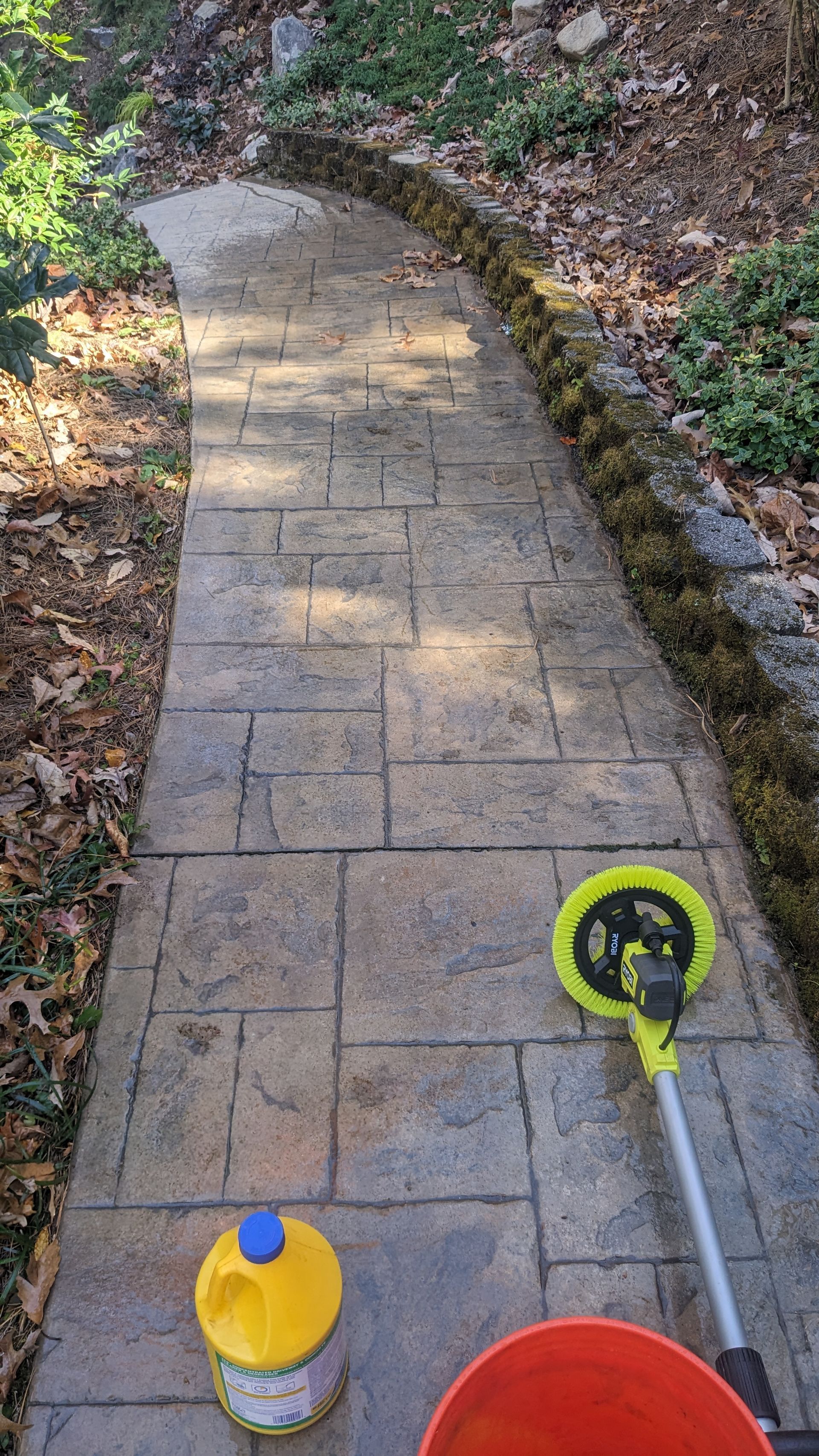 A concrete walkway with a hose and buckets on it.