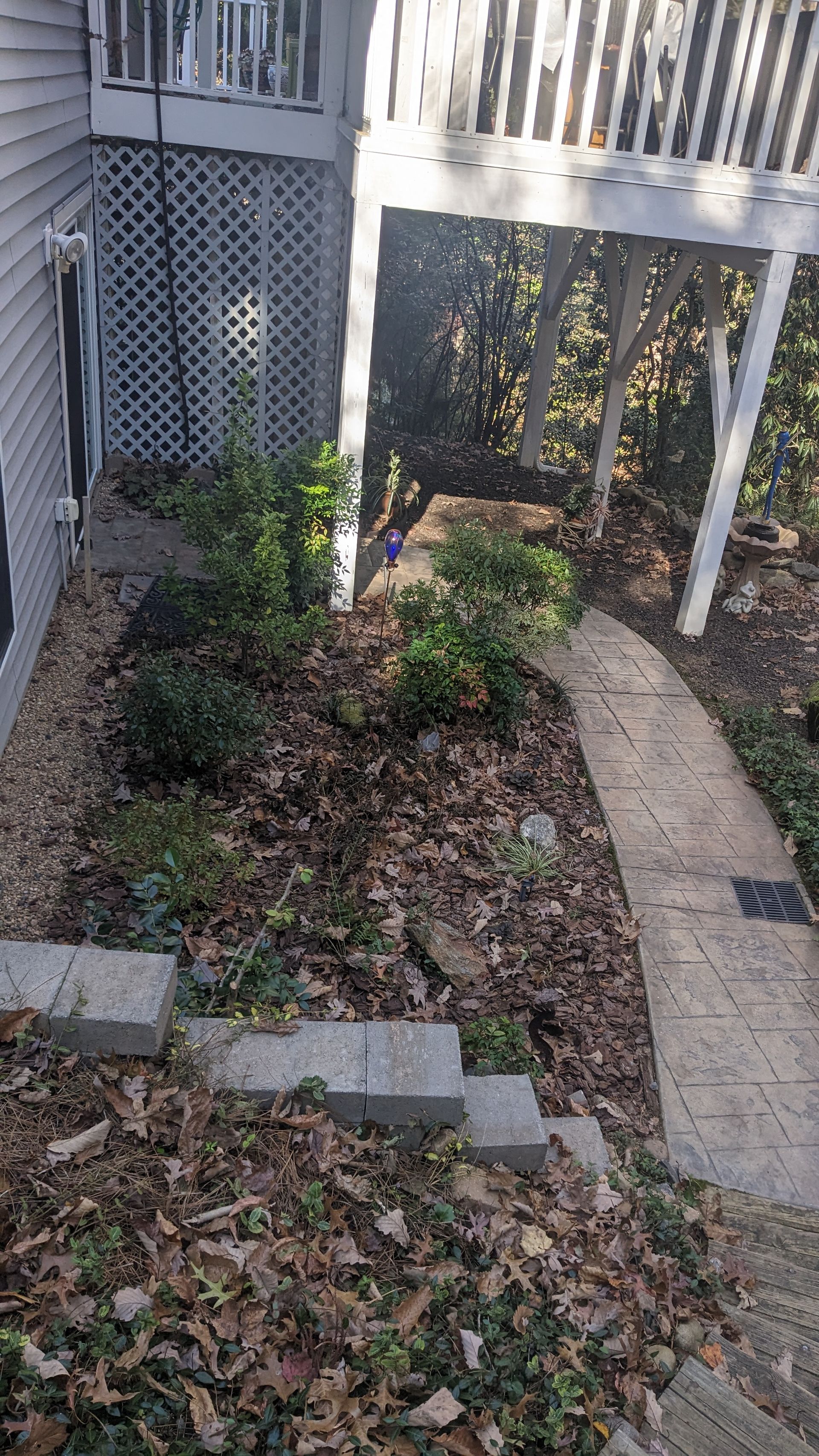 A walkway leading to a house with a pergola in the background.