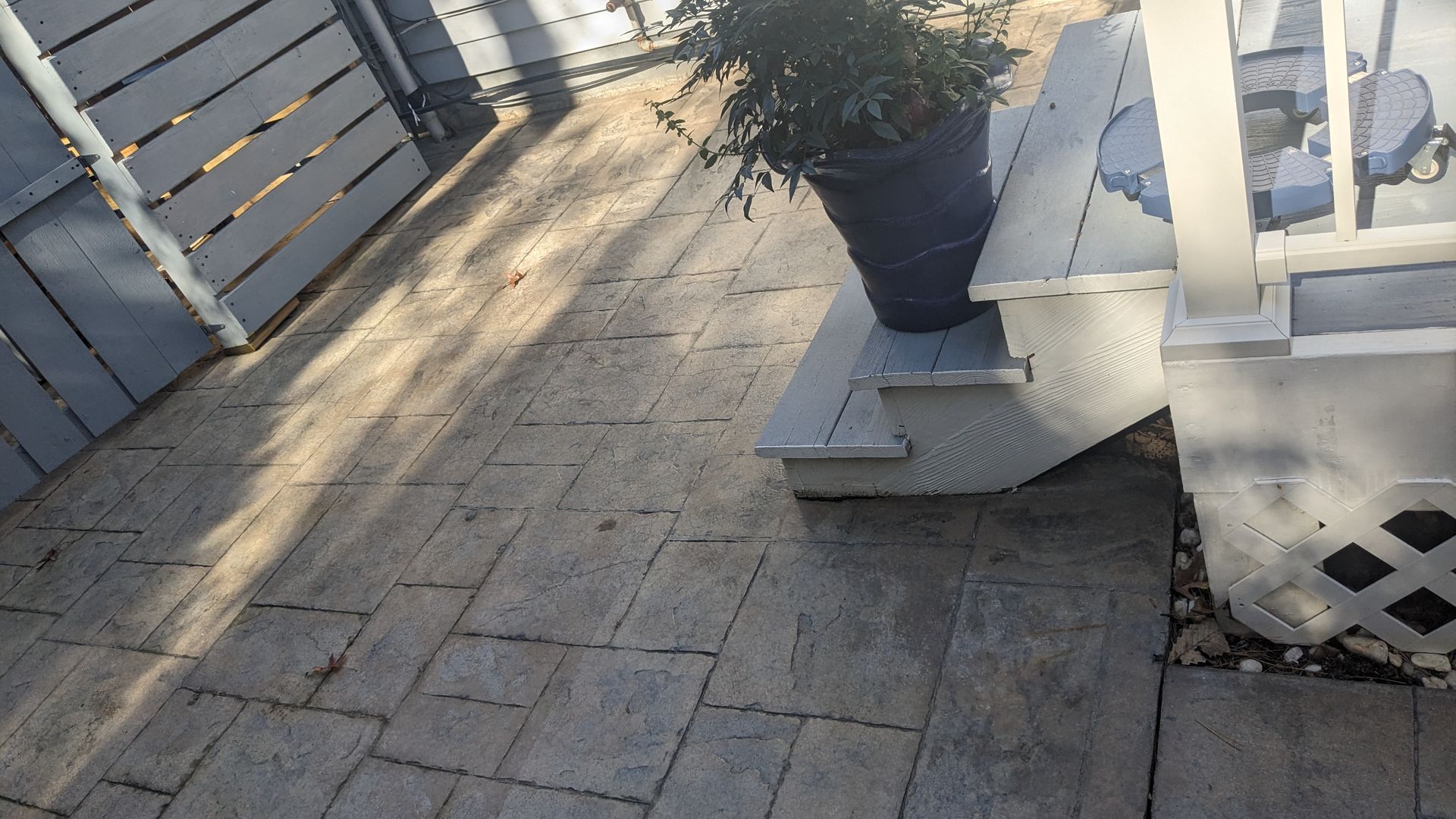 A potted plant is sitting on the steps of a porch.