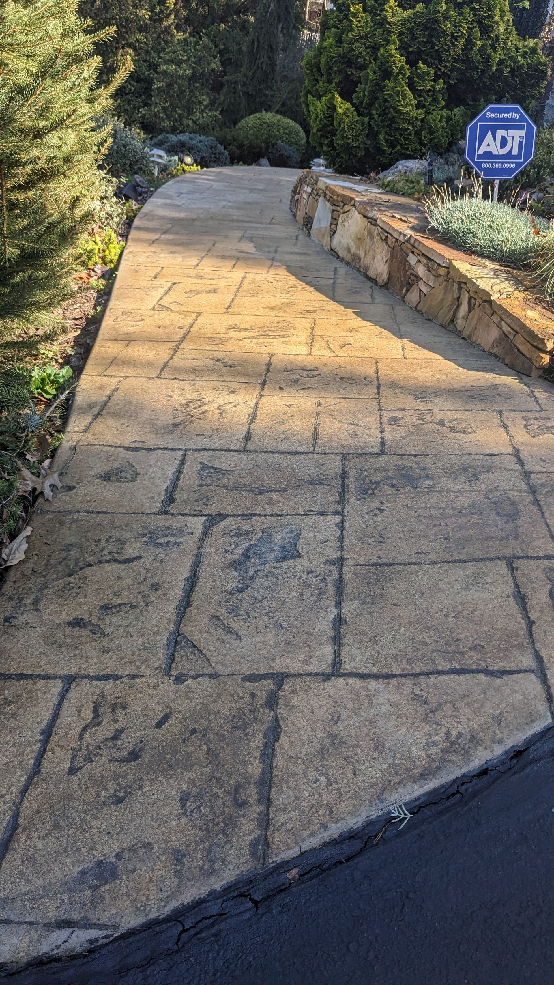 A concrete walkway with a sign on the side of it.