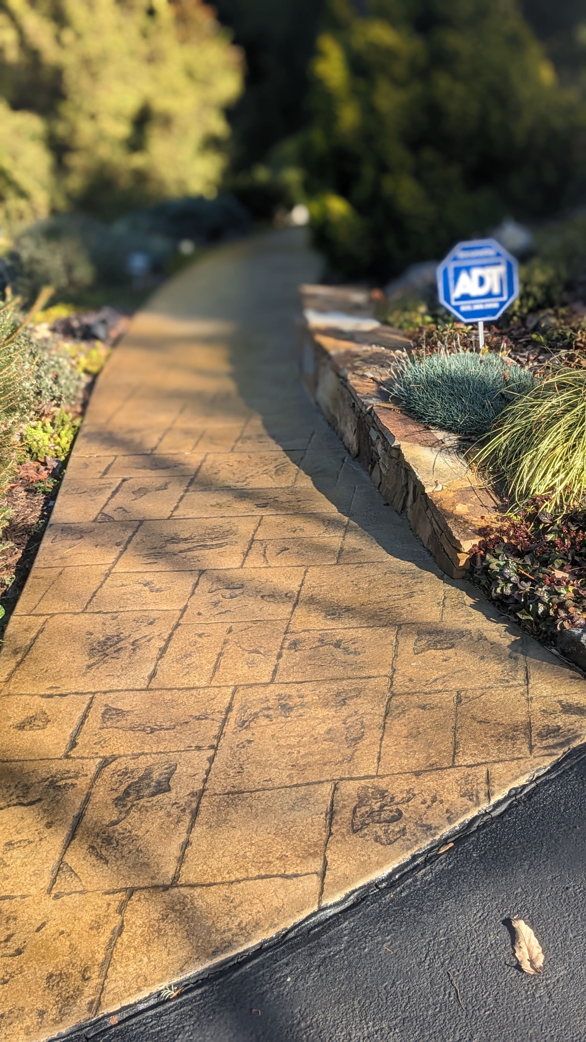 A concrete walkway with a sign on the side of it.