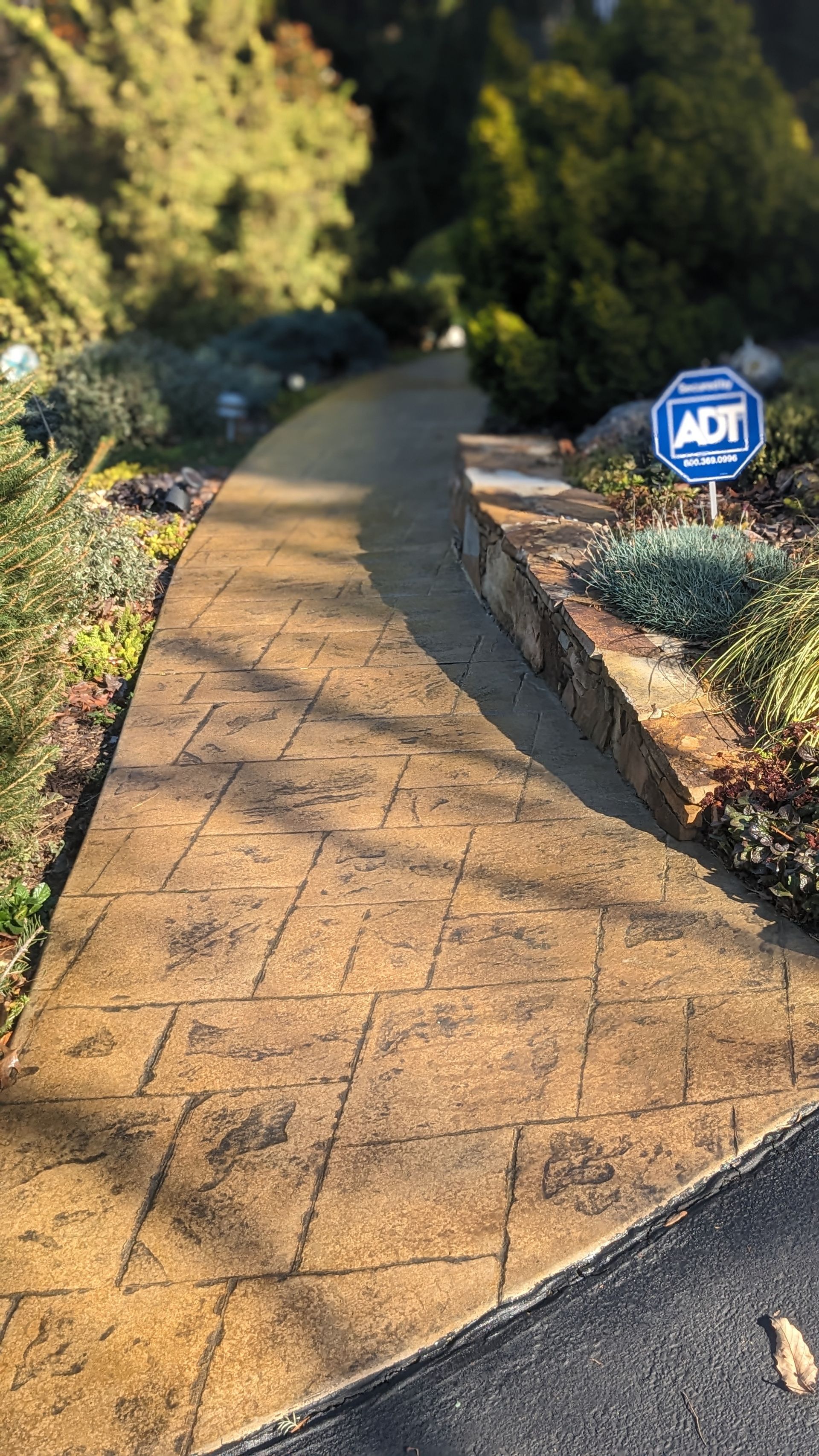 A concrete walkway with a sign on the side of it.