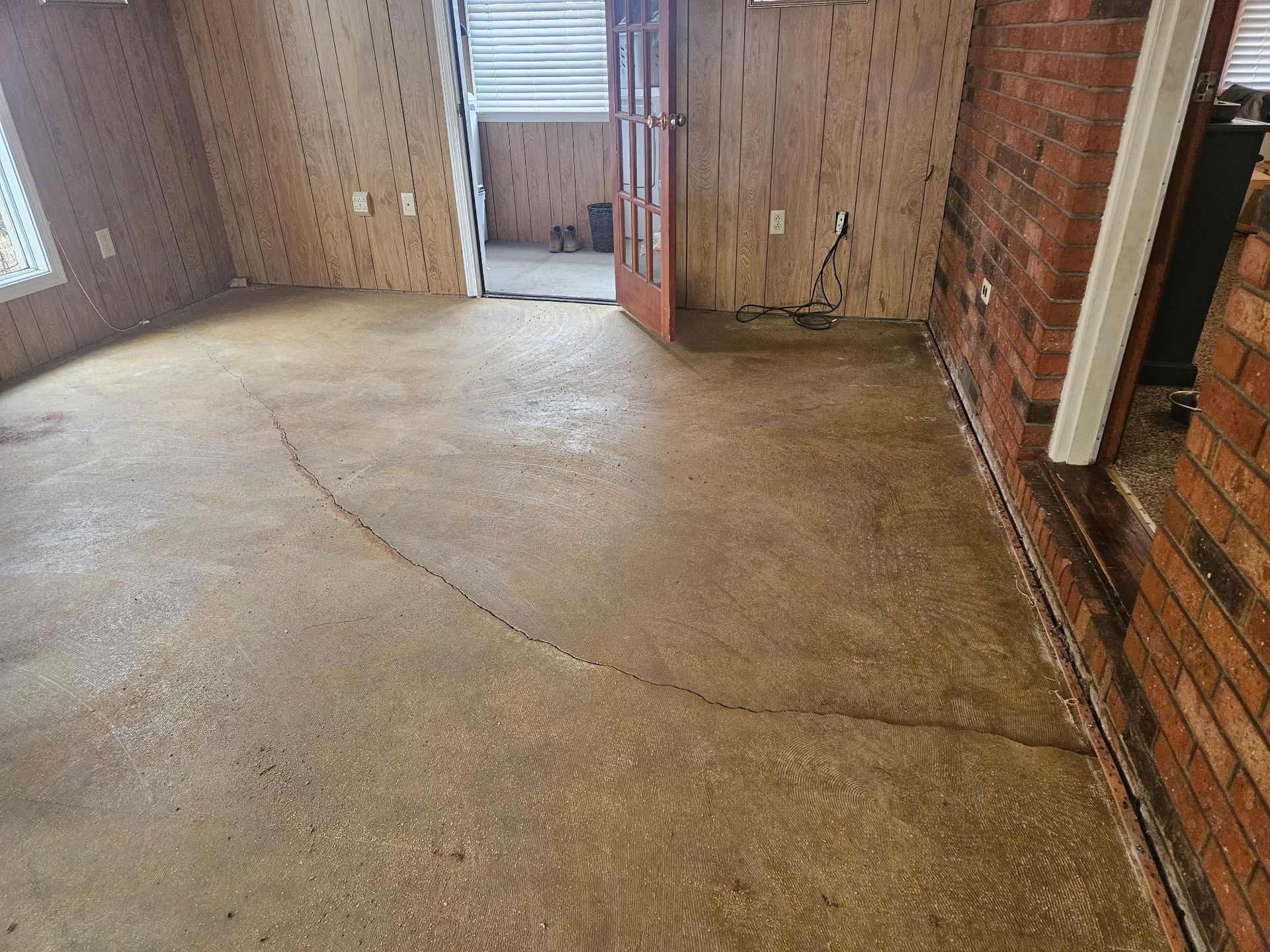 Self-leveling mix curing in wood-trimmed hallway installed by Zachary Daniel Concrete in Pickens, SC.