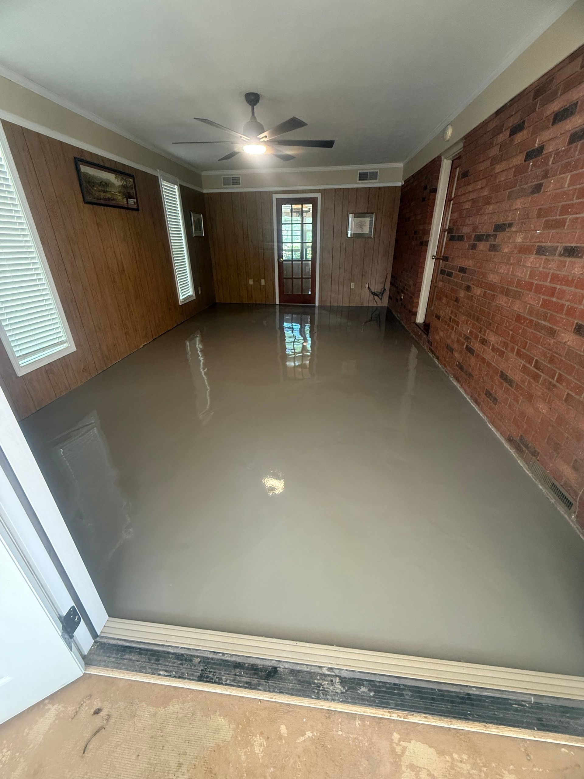 Smooth self-leveling overlay reflecting window light installed by Zachary Daniel Concrete in Easley, SC.