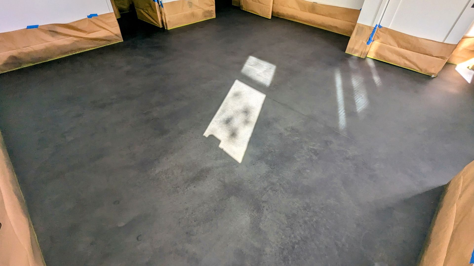 A room with a black floor and a white stencil on it.