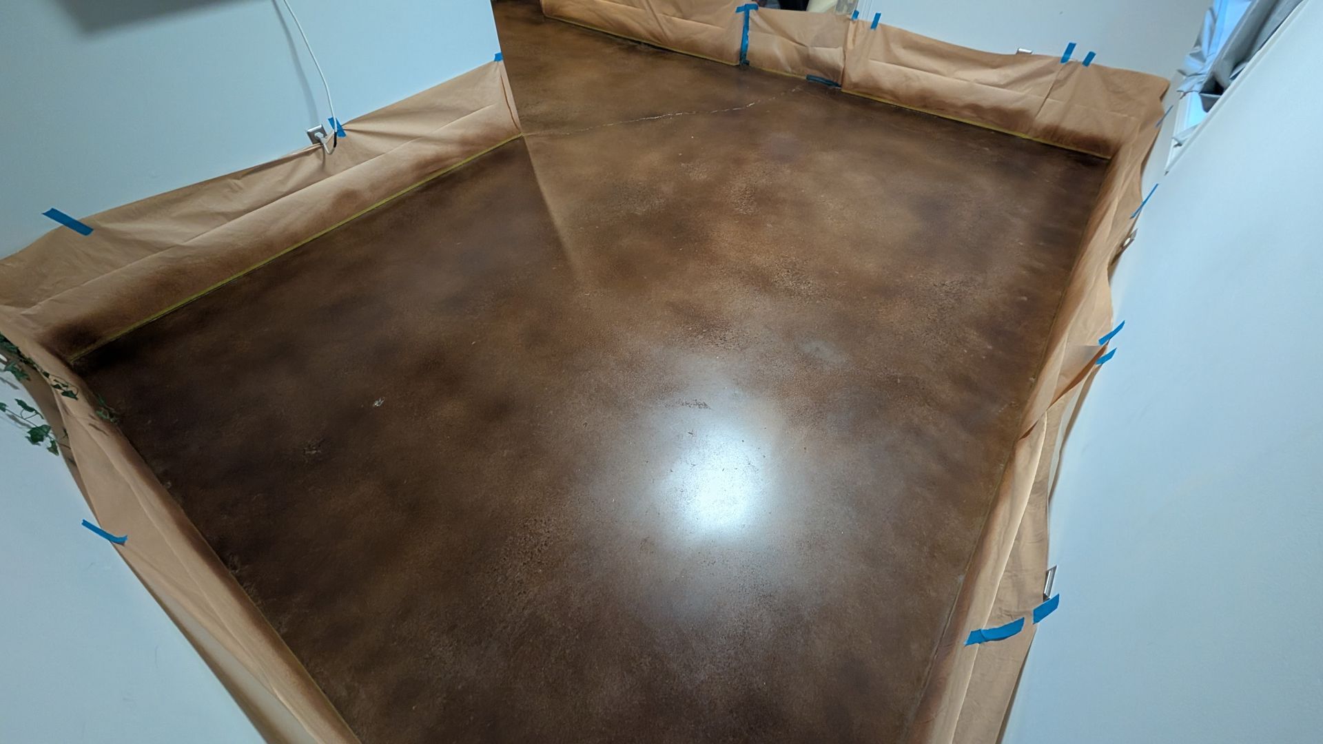 A concrete floor is being painted in a room.
