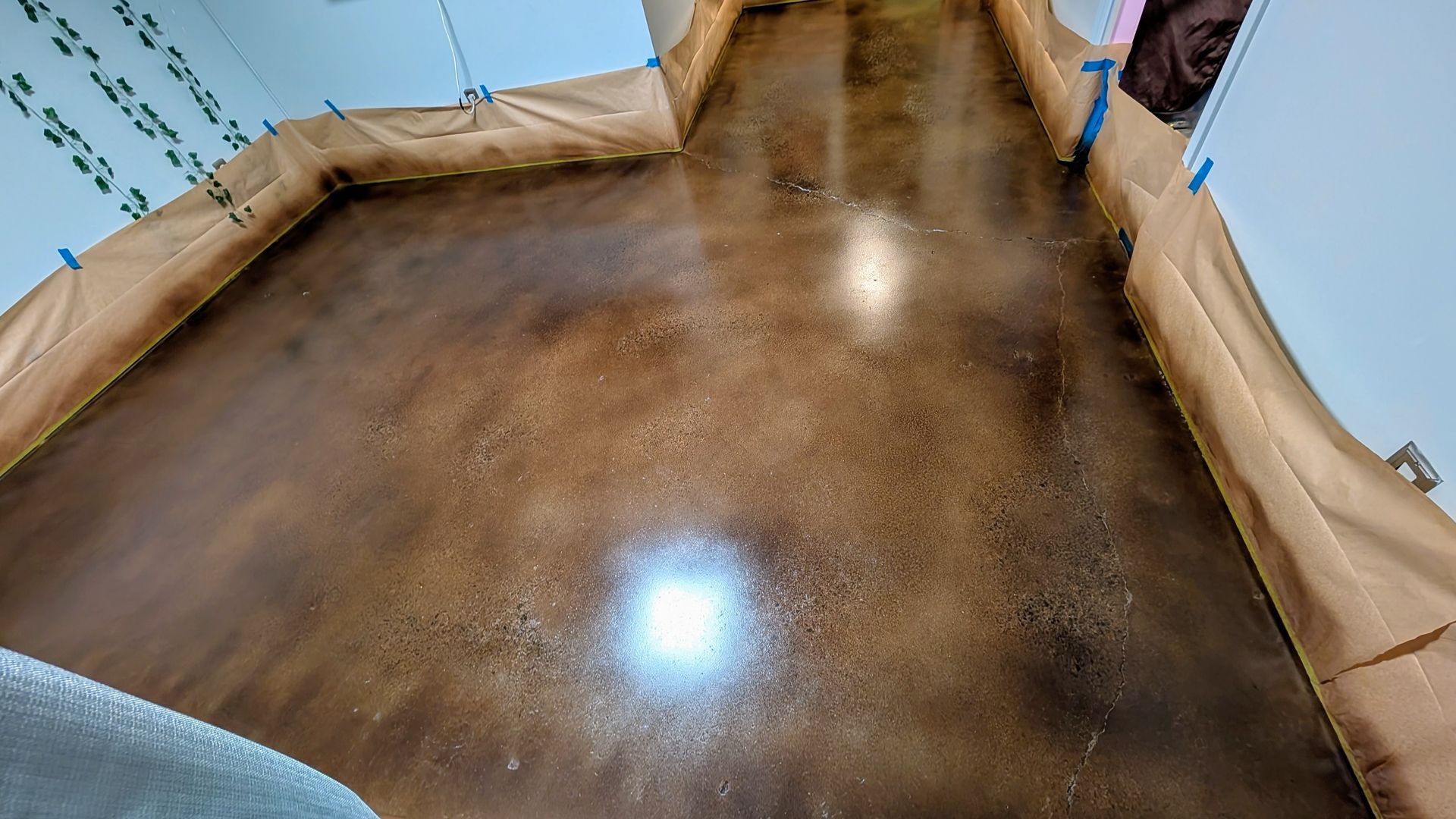 A concrete floor is being painted in a room.