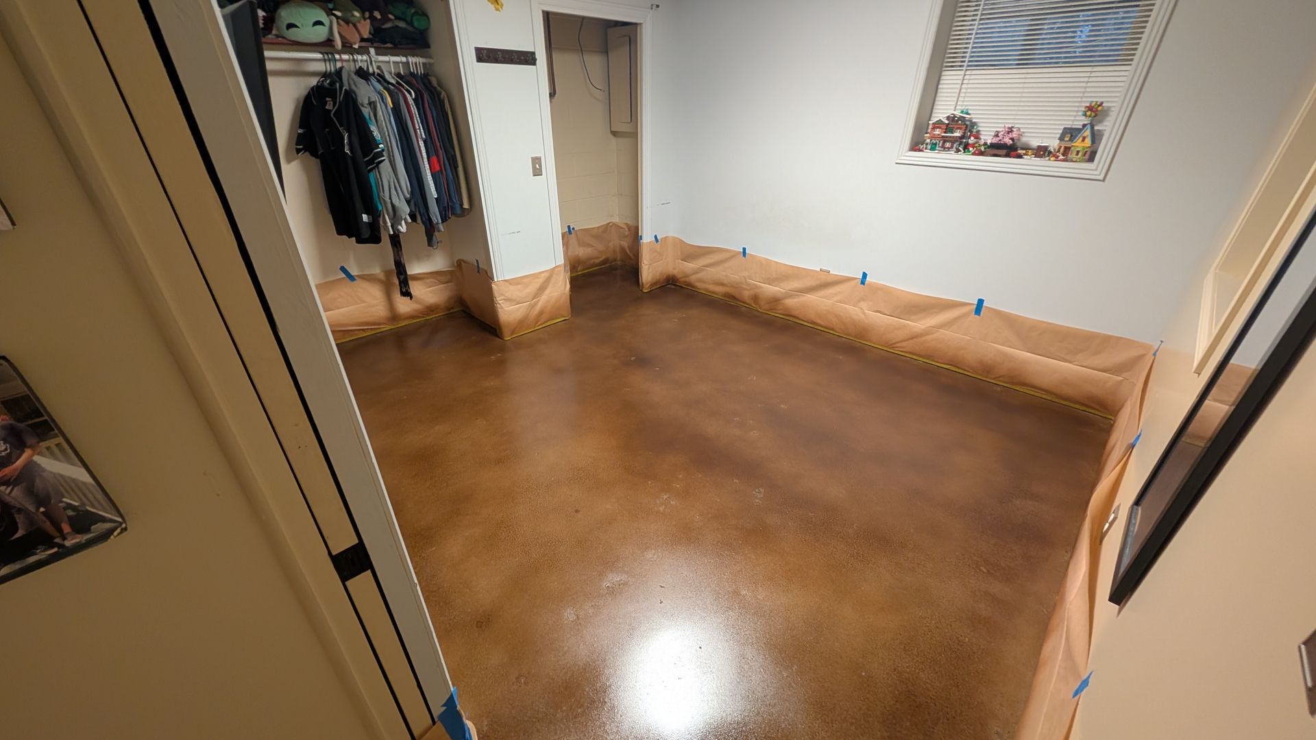 A room with a stained concrete floor and a closet.