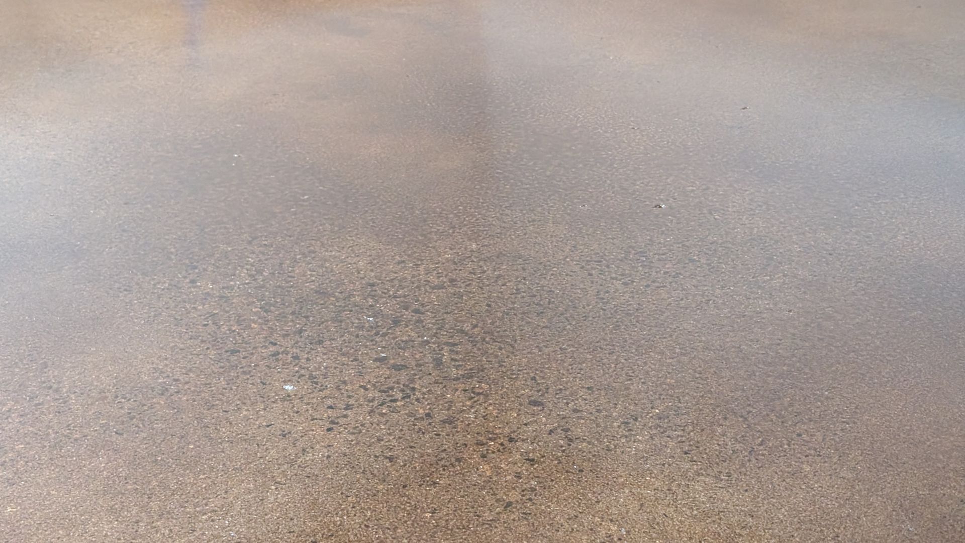 A close up of a concrete floor with a lot of small stones on it.