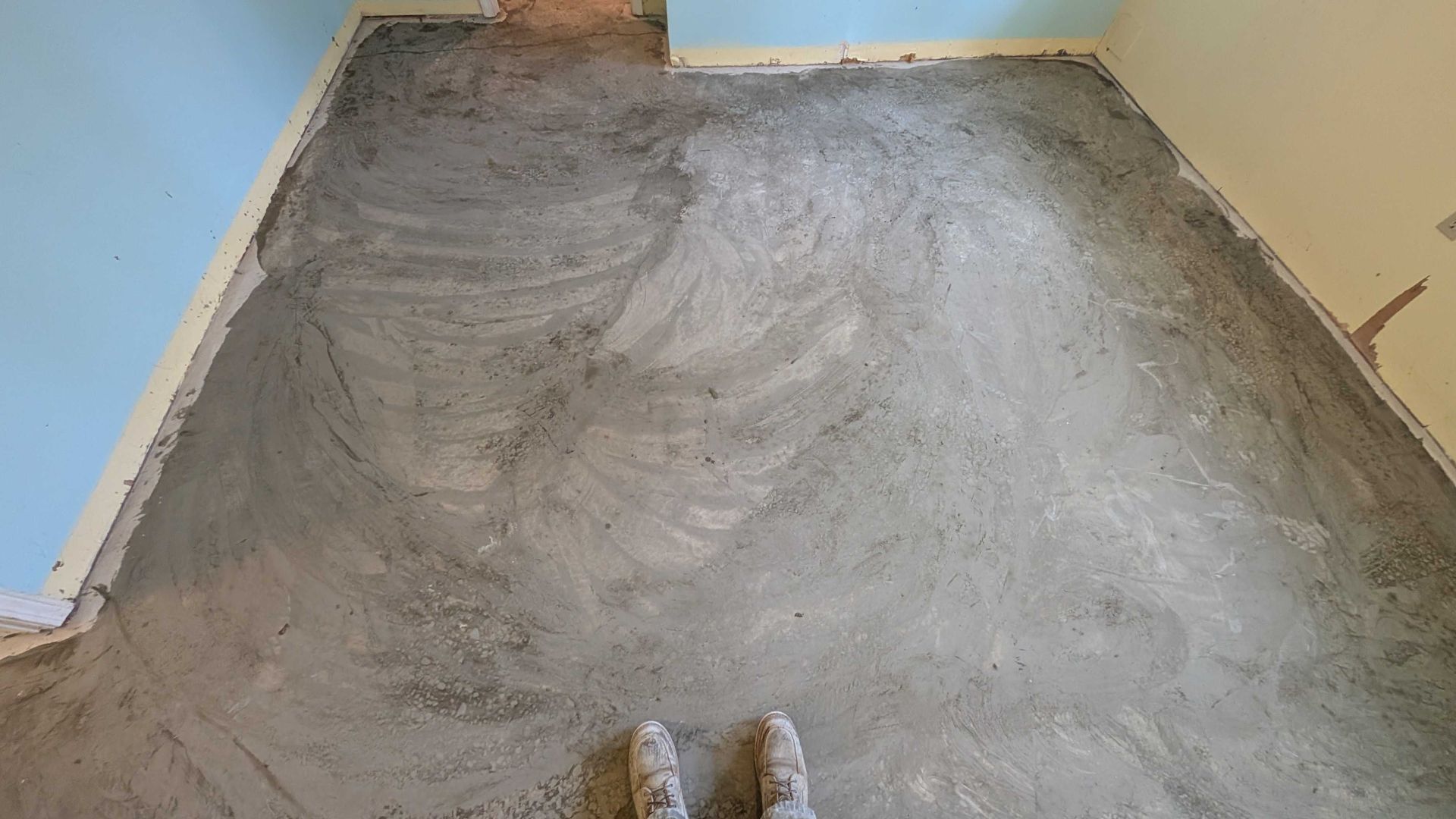 A person is standing on a concrete floor in a room.