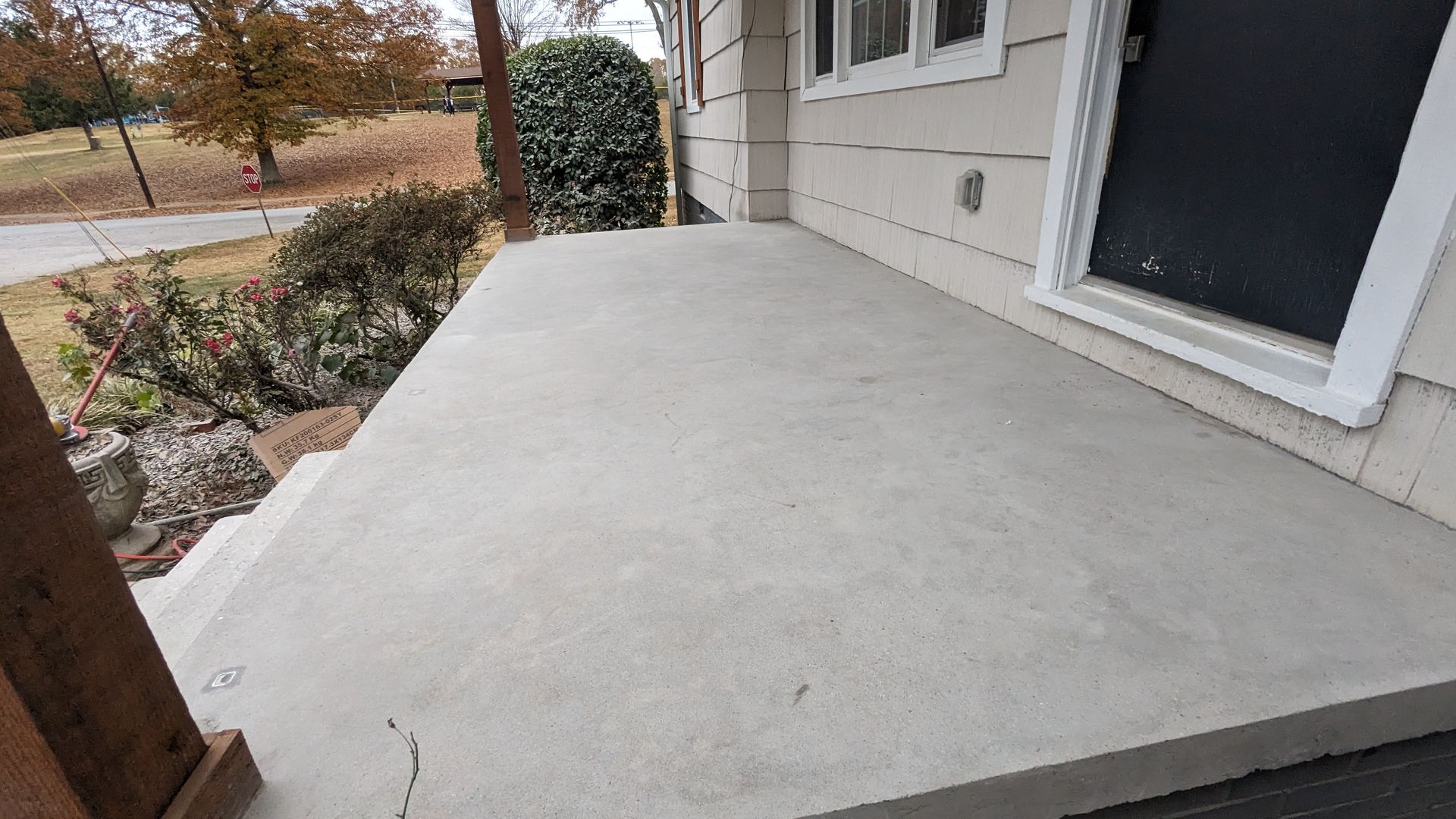 A concrete porch with steps leading to the front door of a house.