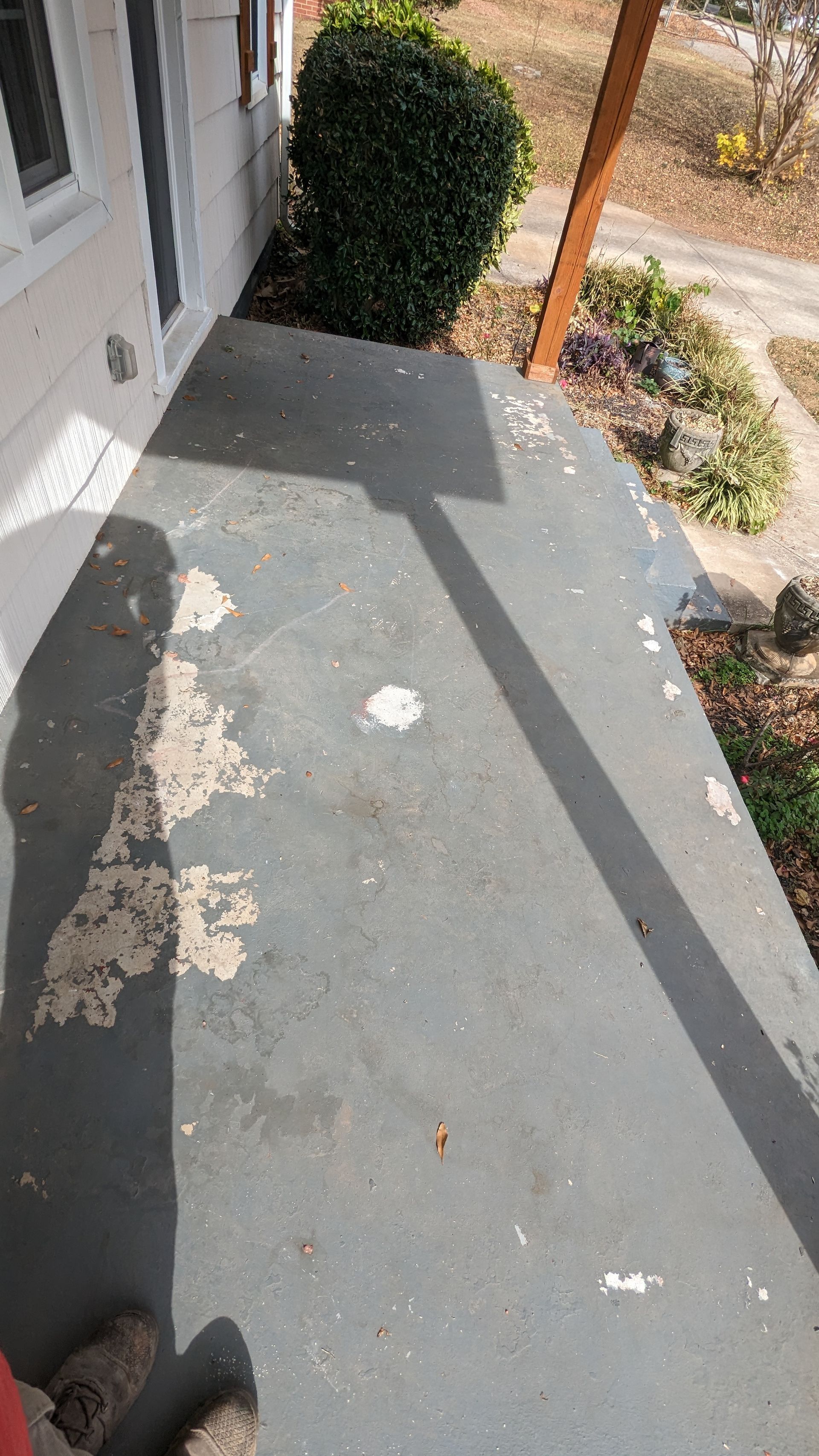 A porch with a shadow of a person on it.