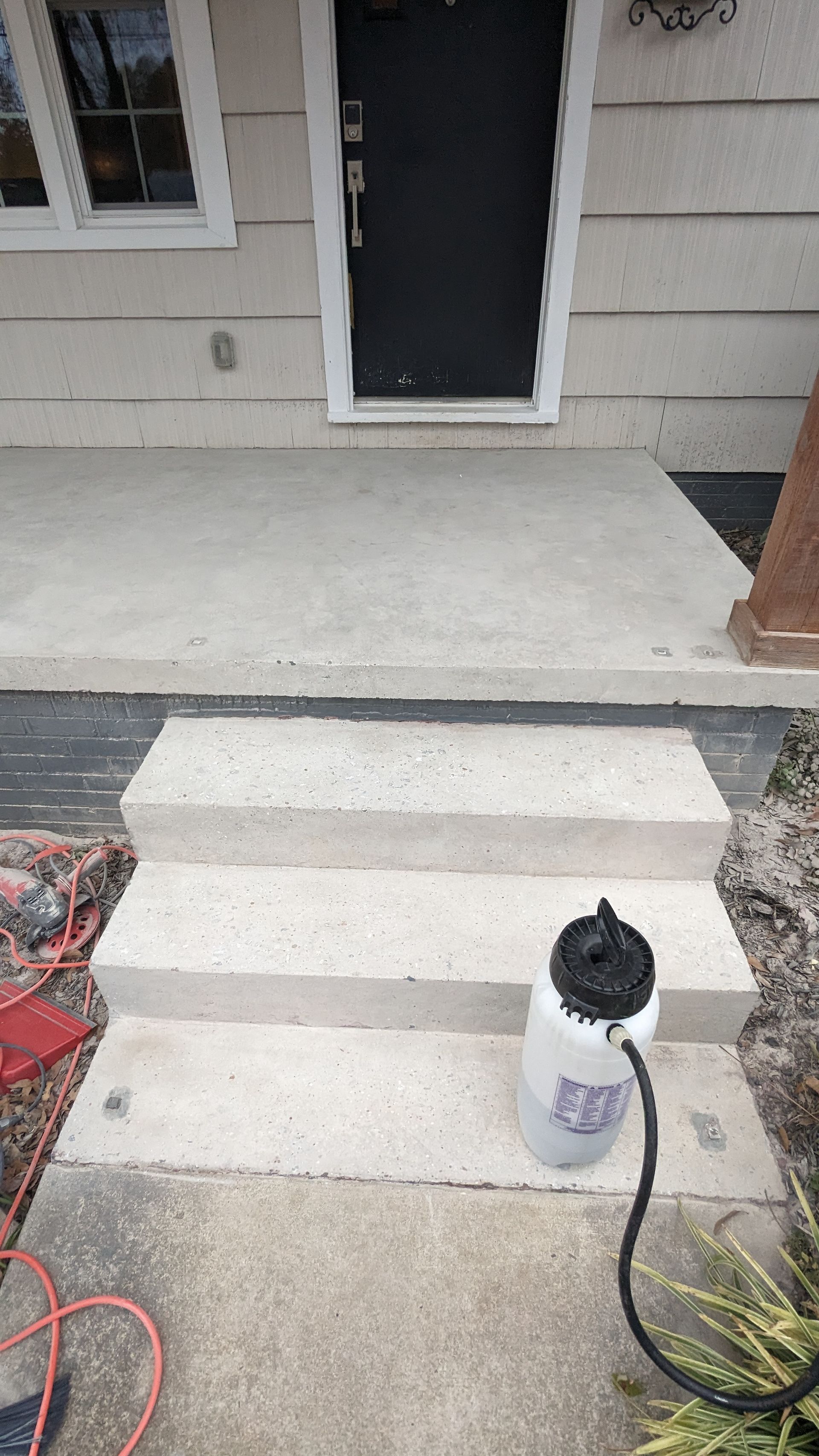 A bottle of water is sitting on the steps of a house.