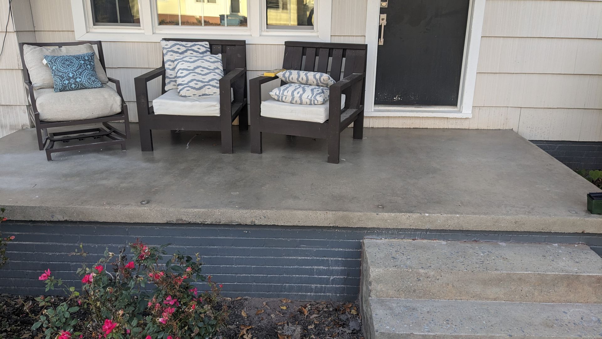 A porch with two chairs and a table on it